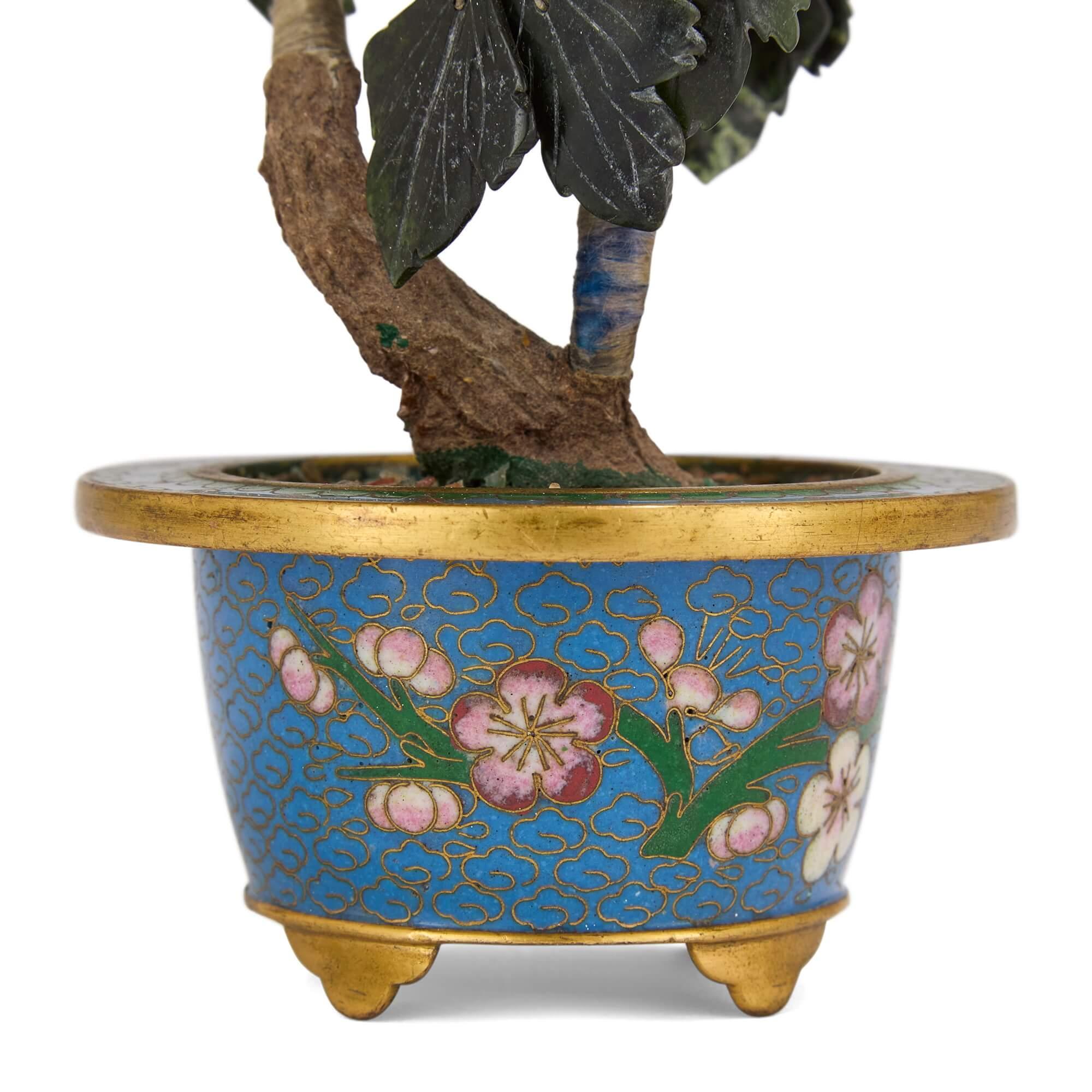 Modèle de fleur en jade chinois, cornaline et quartz dans un cache-pot en émail cloisonné
Chinois, 20e siècle
Hauteur 18cm, largeur 9cm, profondeur 9cm

Ce charmant modèle de fleur combine plusieurs fleurs en pierre dure précieuse avec un cache-pot