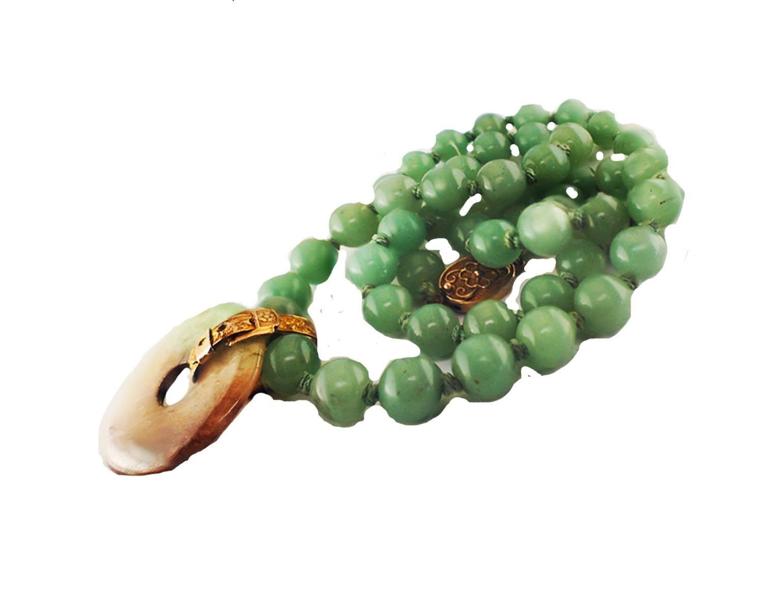 Chinese Jade Disk and Bead Necklace attached with a 14 Karat Yellow Gold buckle style ornament 
Retro, 1970's Pendant and Bead necklace displays a convex jade with marbled colors of Brown, Green and White.
The Jade is 1.25 inches in diameter 

The