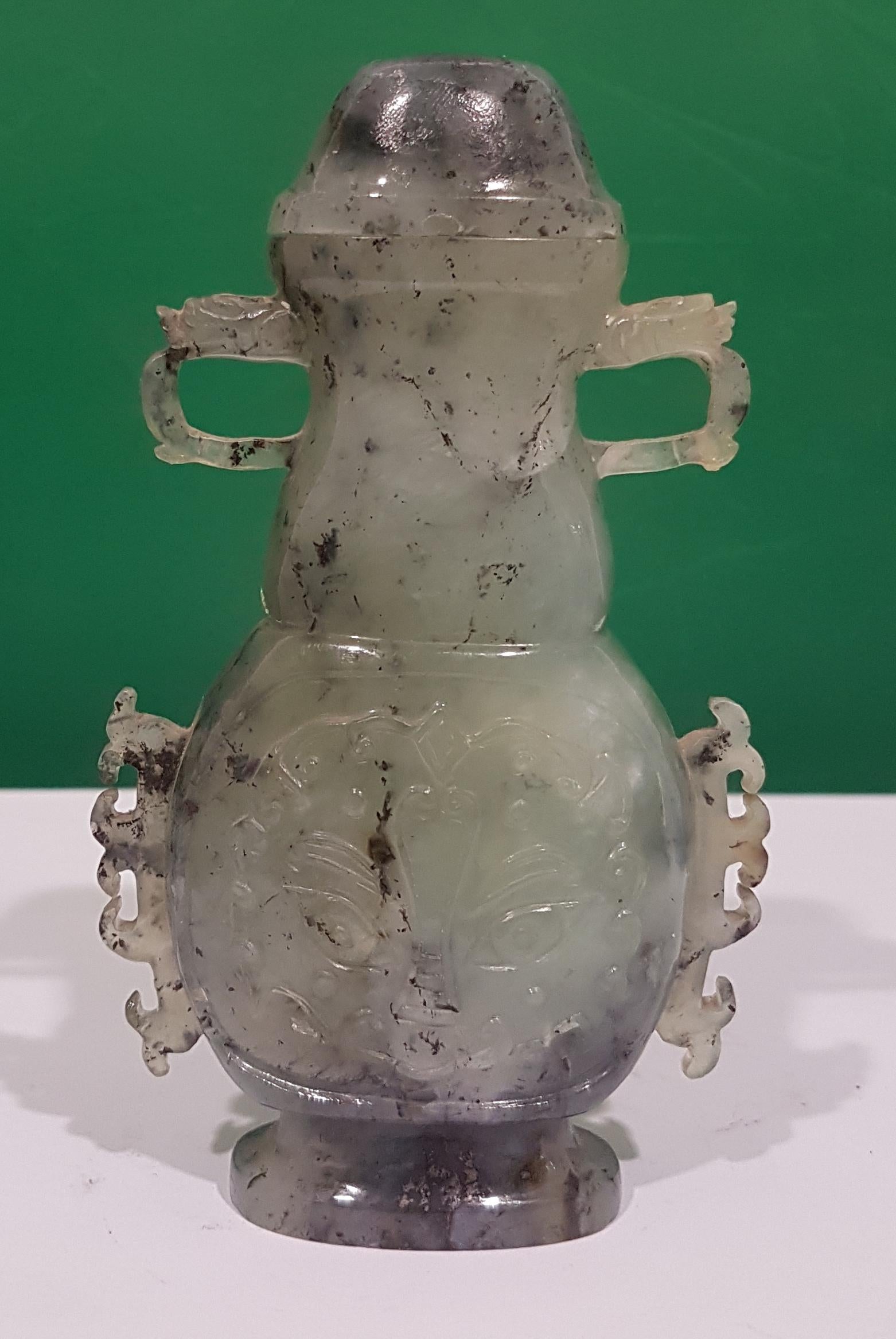 Jade pot / incense burner, Chinese manufacture, 20th century.
Green jade carved with decorations, cover and handles modeled as heads of Chinese dragons.

  