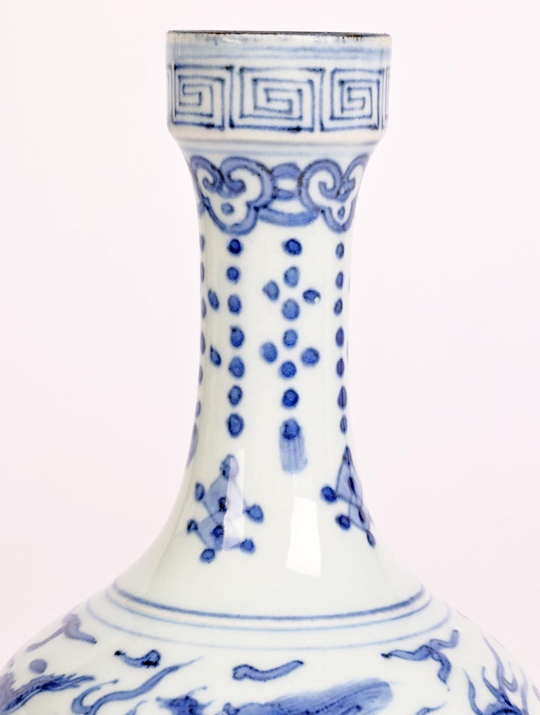 A good quality Chinese blue and white porcelain vase decorated with dragons chasing flaming pearls with Ming Jiajing (1522-66) marks to the base but probably later. The vase stands on a narrow round base with a wide squat lower body and with tall