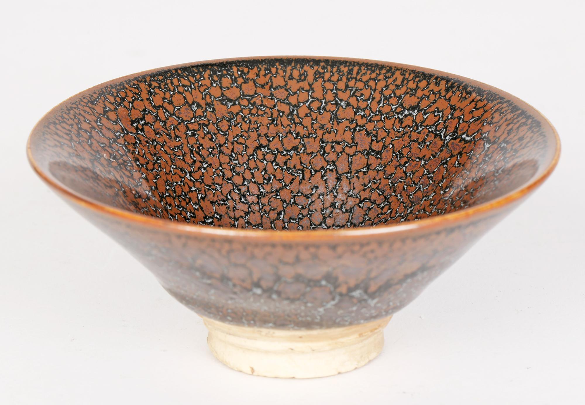A very impressive and stylish Chinese brown oilspot pattern glazed pottery tea bowl in the Jian Ware style believed to date from the 20th century or possibly earlier. The round conical shaped tea bowl stands on a narrow round unglazed foot and is