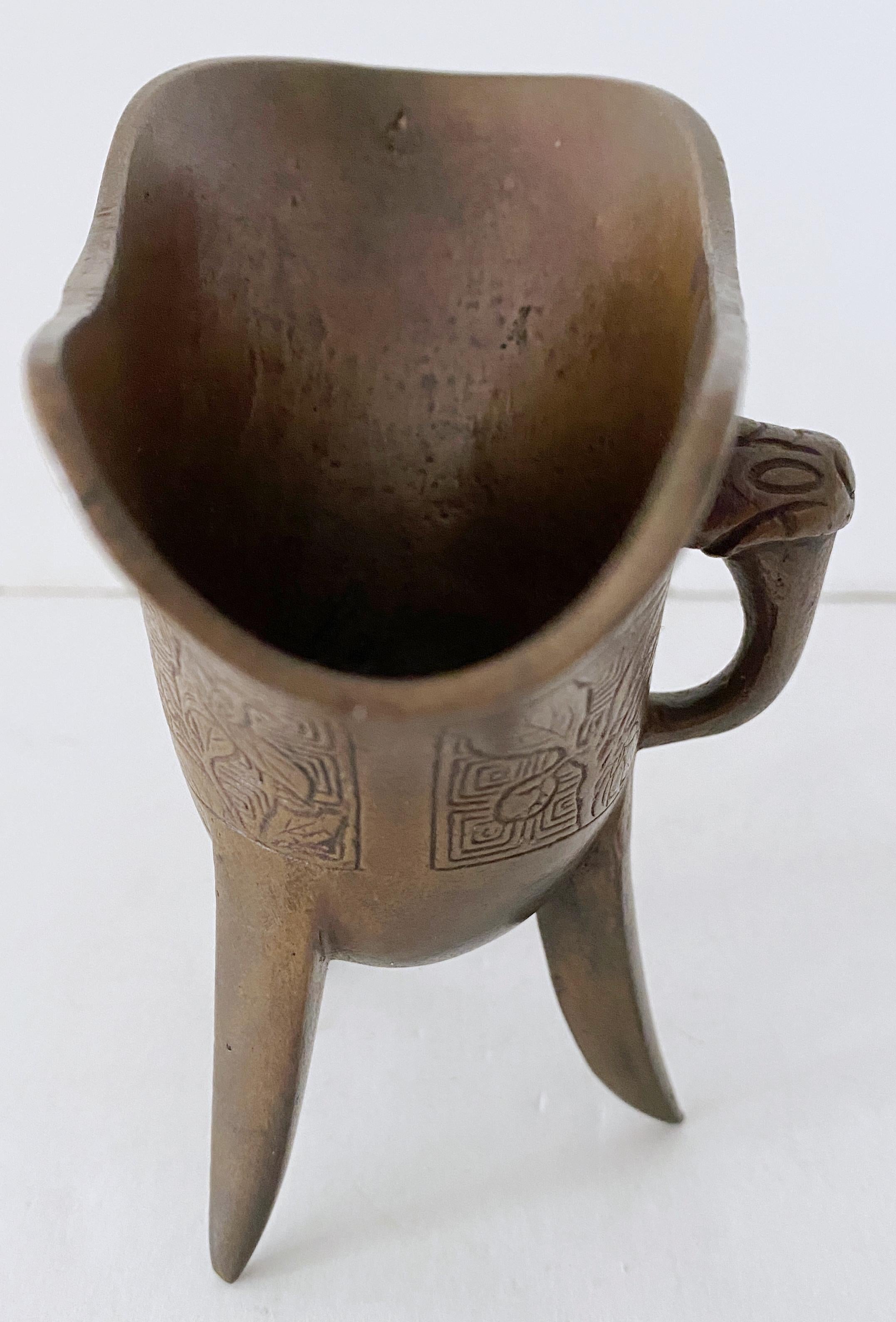 Chinese Jue, Bronze Ritual Wine Vessel, Honorific Mark, 20th Century or Older 
This exquisite Chinese bronze ritual wine vessel, known as a jue, is a beautiful example of archaistic design, dating from the 20th century or earlier. The vessel