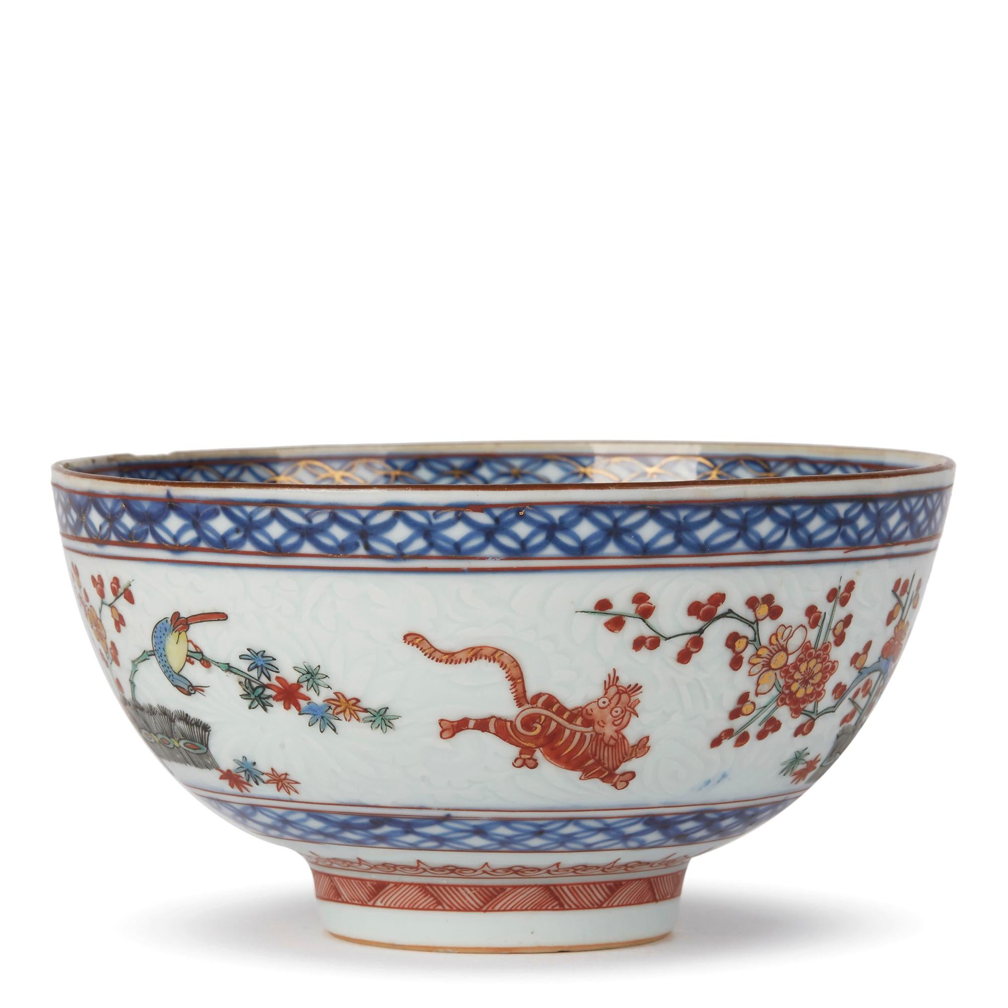A very finely hand painted antique Chinese Kangxi Kakiemon ware porcelain bowl, probably Dutch decorated with an underglaze blue design with Fine floral relief moulding to the body over painted with a flowering prunus set in a banded hedge, a bird