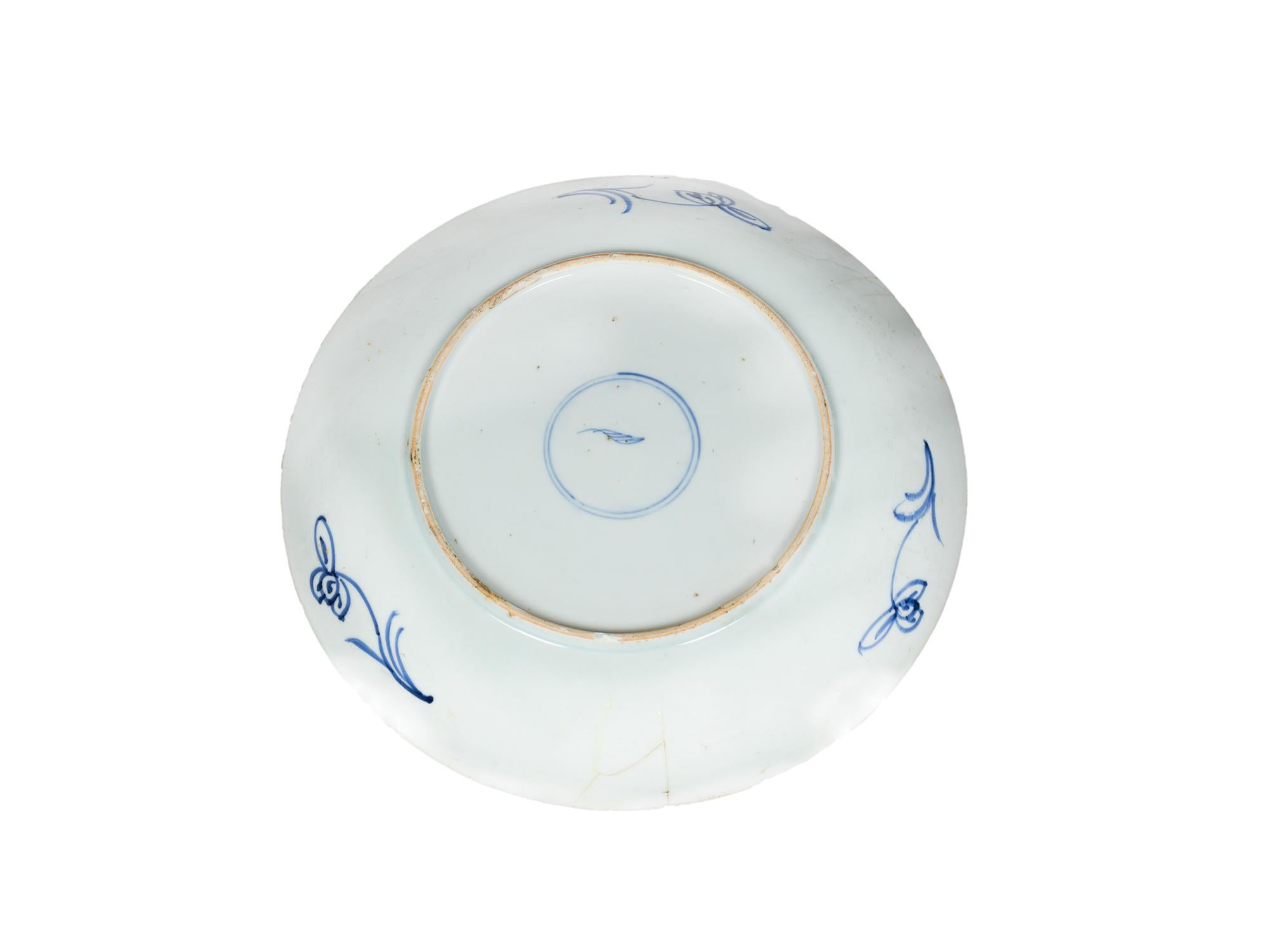 A huge, rare, and authentic Chinese Kangxi porcelain plate or shallow dish from the early Kangxi period of the 17th century, hand-decorated with flowers on the underside of the rim and hand-painted in Canton blue and white with the Aster flower