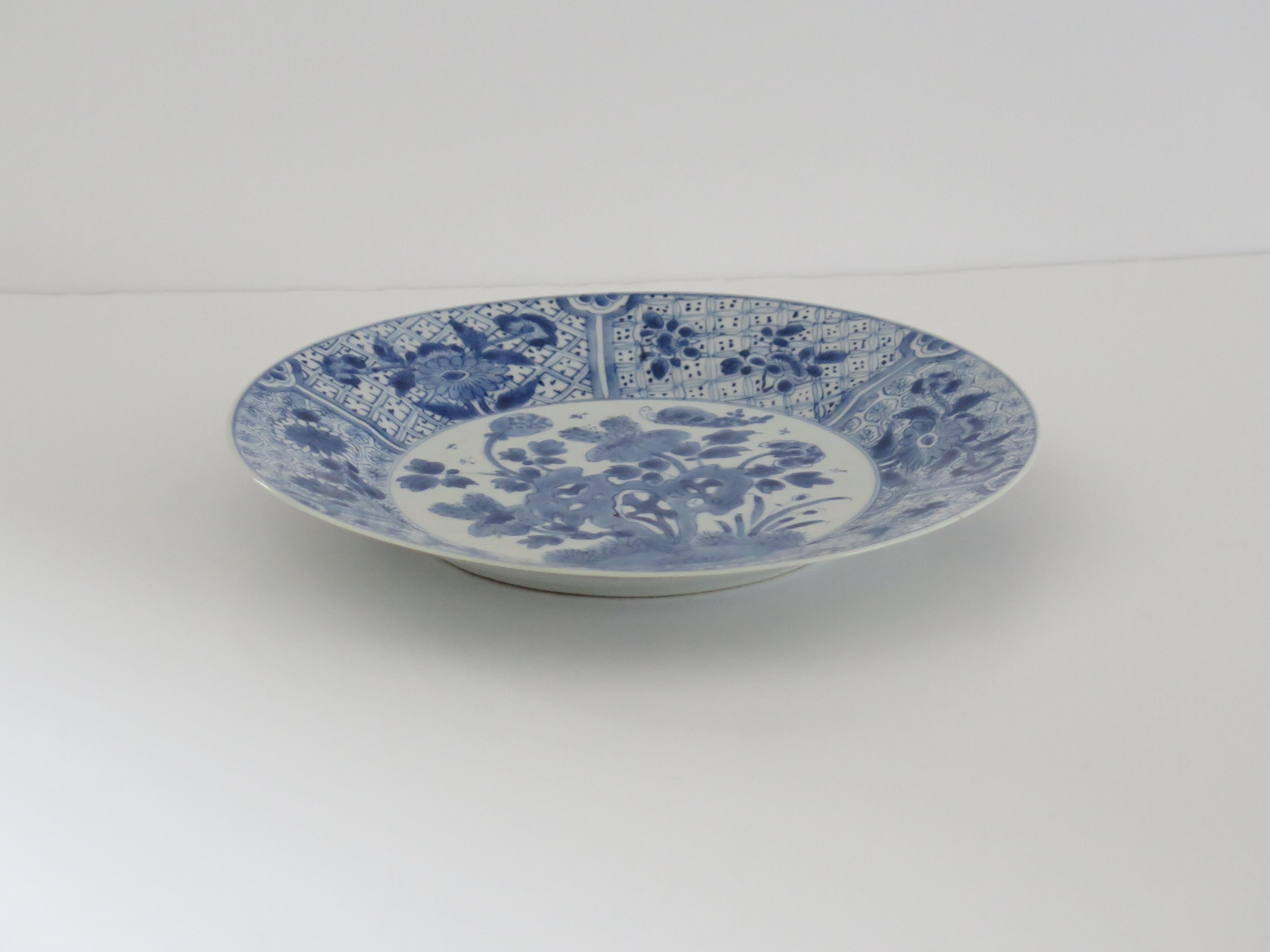 This is a very beautifully hand-painted Chinese porcelain blue and white large plate or Dish, from the Qing, Kangxi period, 1662-1722.

The plate / dish is finely potted with a carefully cut base rim and a lovely rich glassy, very light blue glaze