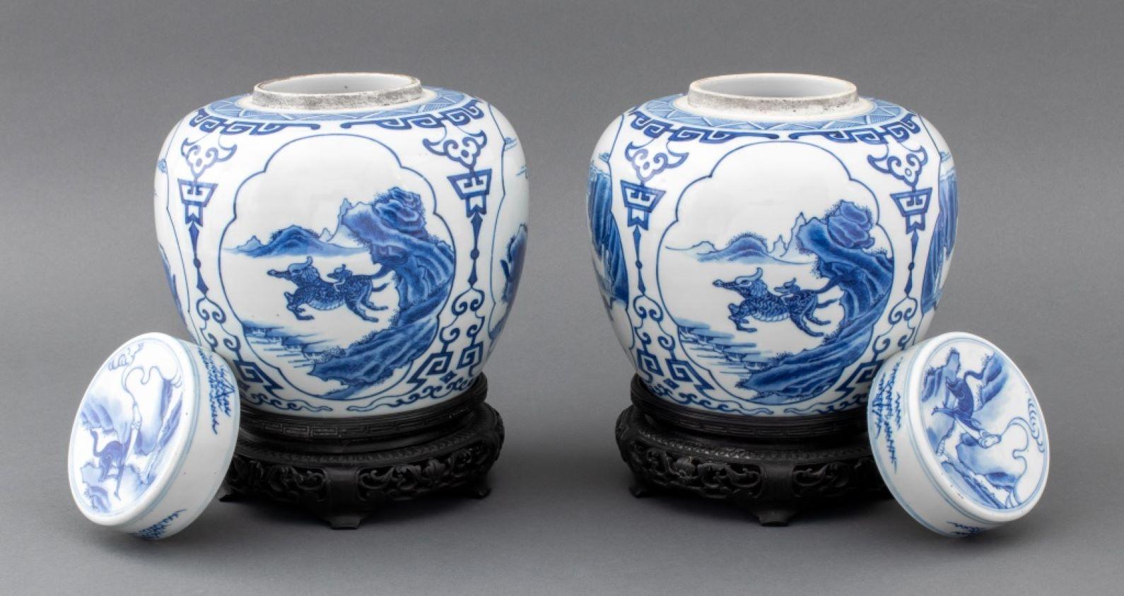 Pair of Chinese Blue and White Porcelain Lidded Ginger Jars, with mystical creature motif, cobalt blue overglaze Kangxi six character mark in double circle to underside, on carved wood stands. Overall: 10.25