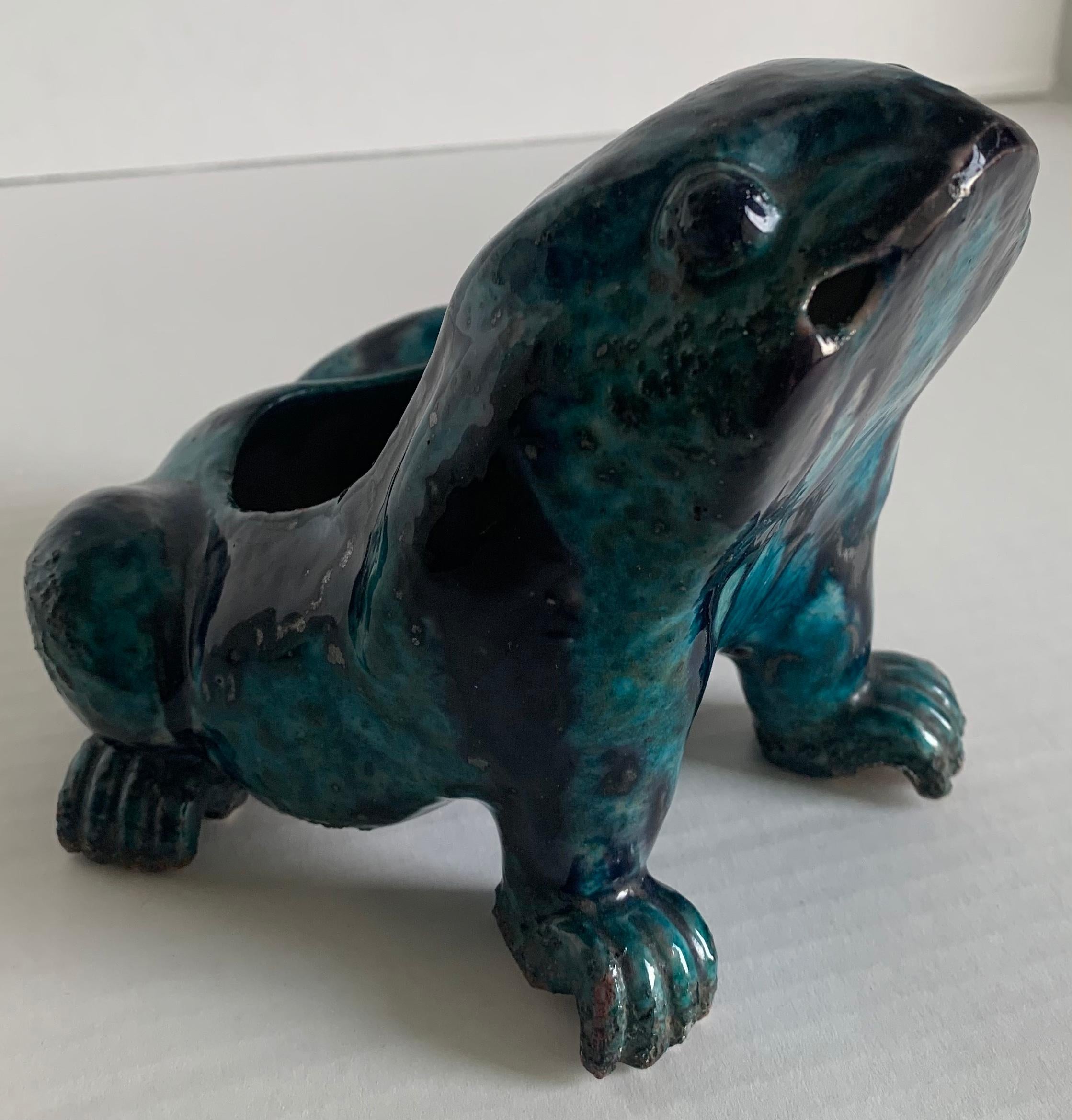 Kangxi period (1662-1722) turquoise & aubergine glazed porcelain frog. Covered in an overall rich turquoise & aubergine glaze. 
This charming frog is modeled in a seated position with its head held high in an amusing expression. 
Provenance: Ralph