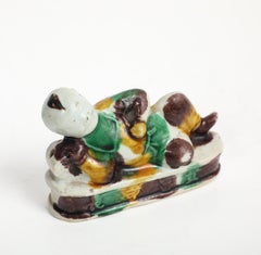 Chinese Kangxi Period Sancai “Egg-and-Spinach” Porcelain Reclining Laughing Boy