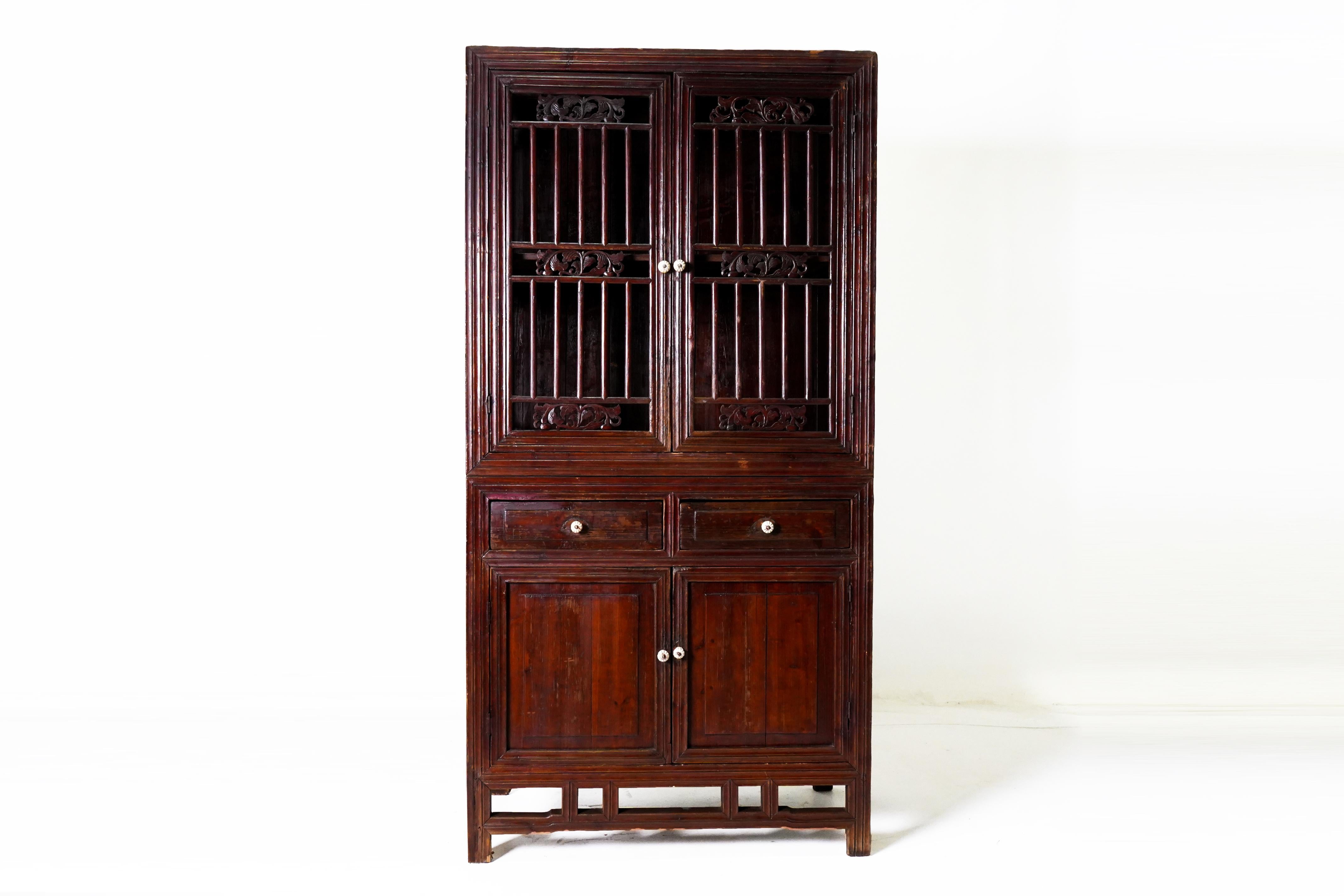 This Chinese kitchen cabinet is made from Chinese Cypress Wood and covered in a protective coat of natural oxblood lacquer. The cabinet is made in two parts for easy movement between indoor and outdoor coking areas. The open lattice provides a