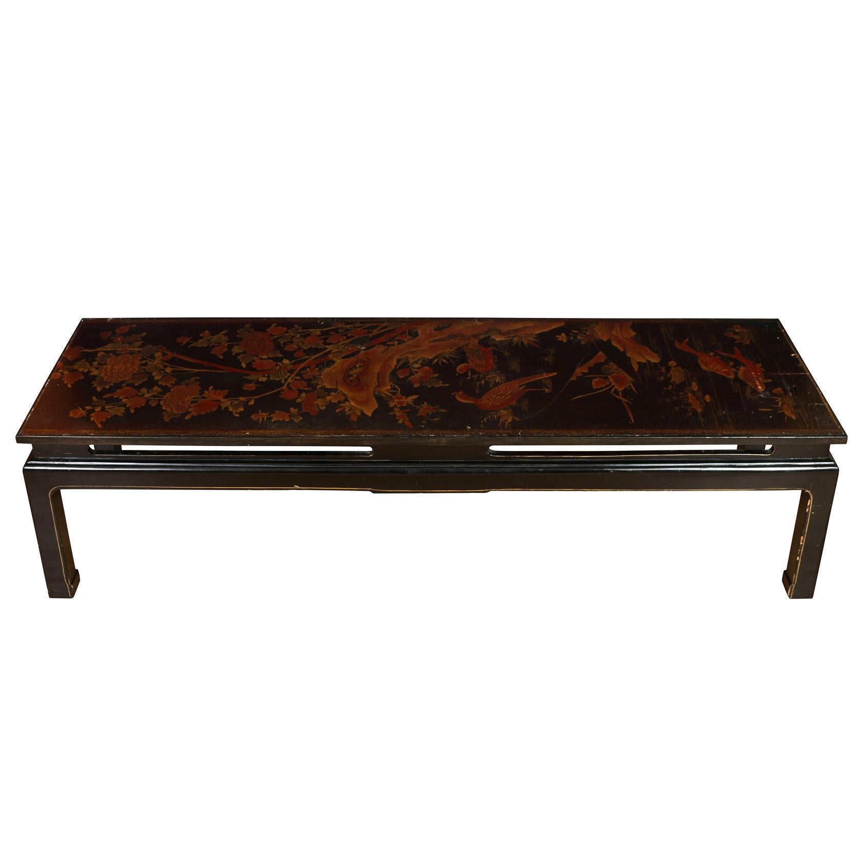 A Chinese lacquer coffee table with parcel gilt decoration including branches, flowers, birds and fish.  Underside of table is also painted with Asian scenery