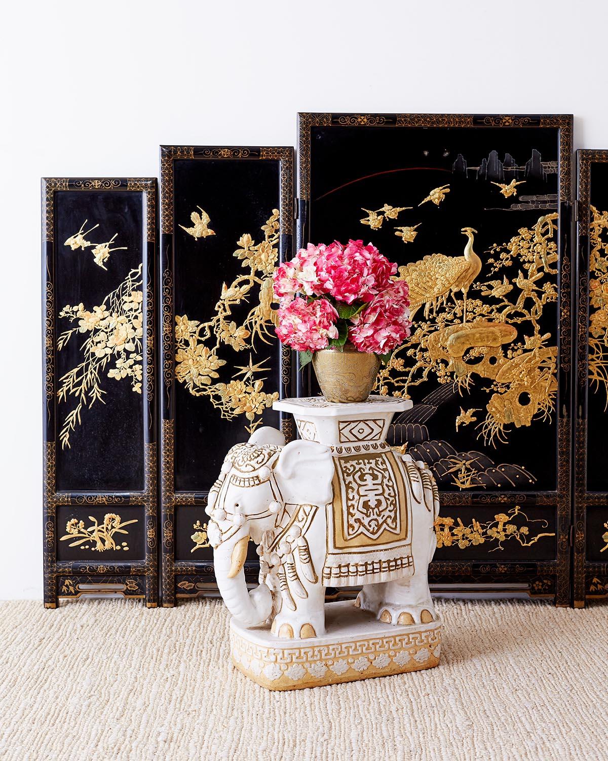 Dramatic Chinese five panel black lacquer screen featuring gilt decoration. The five graduating panels are adorned with scores of flora and fauna in moriage relief style and finished in gilt. The center panel having a large peacock with beautiful