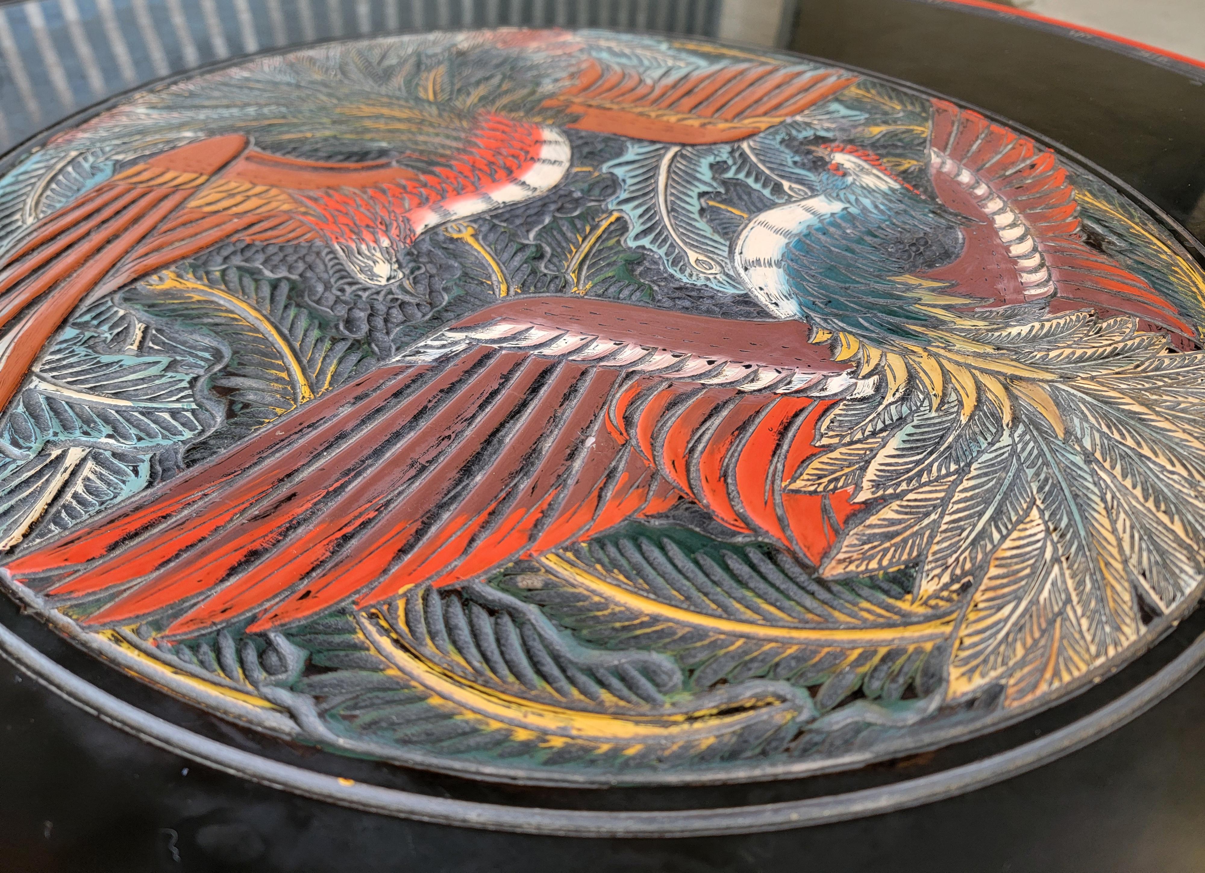 Table basse circulaire laquée et peinte avec des oiseaux peints à la main. Le médaillon central représente deux oiseaux qui semblent être des coqs. Bords laqués noirs avec tablier et pieds sculptés. 

Diamètre de 37,25 pouces
12,63 pouces de hauteur.
