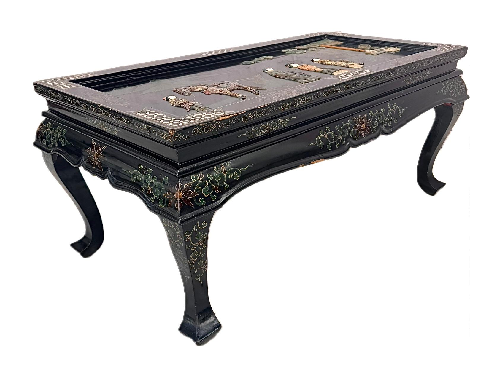 Superbe table à thé et à café chinoise du 20e siècle de style Chinoiserie. La table est ornée d'un motif en nacre et en stéatite représentant des personnages chinois sur le plateau, d'un tablier à volutes contenant des dessins floraux chinois et de