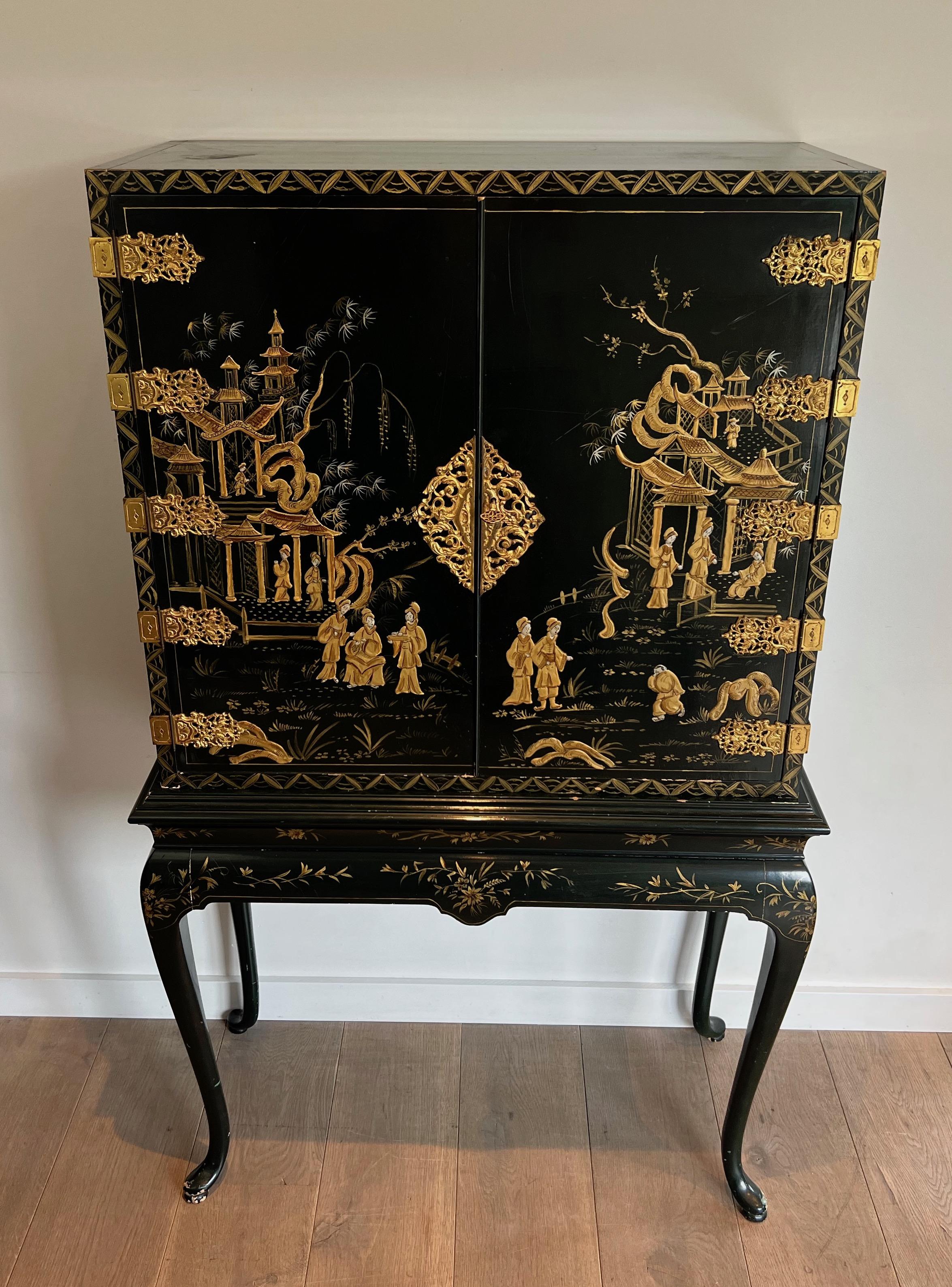 This cabinet is made of green lacquered wood with gilt bronze and chinese life sceenes. The inside part is made of eglomised mirrors. This is a French work, circa 1940.