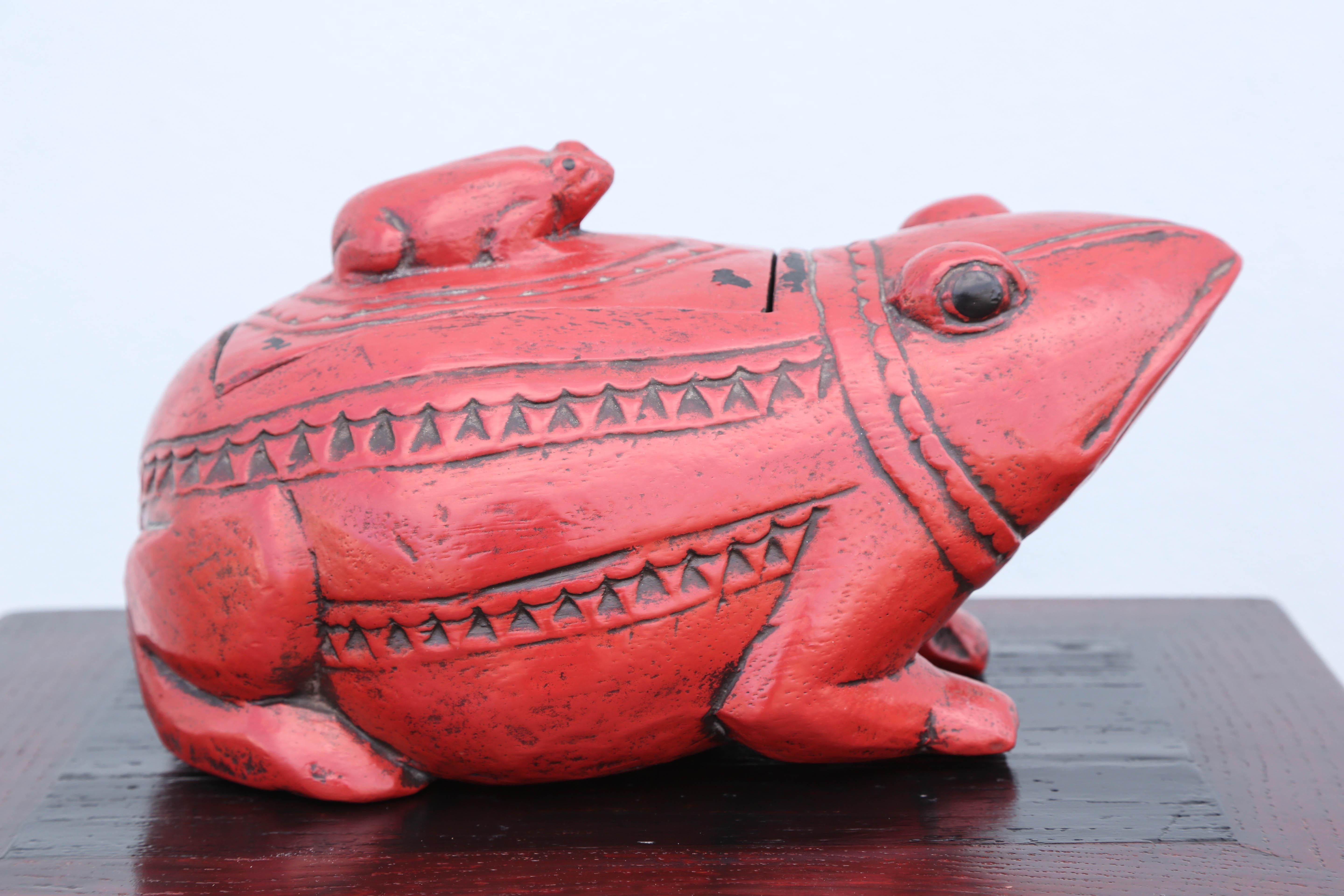 Red lacquered frog box with baby frog as handle on lid.