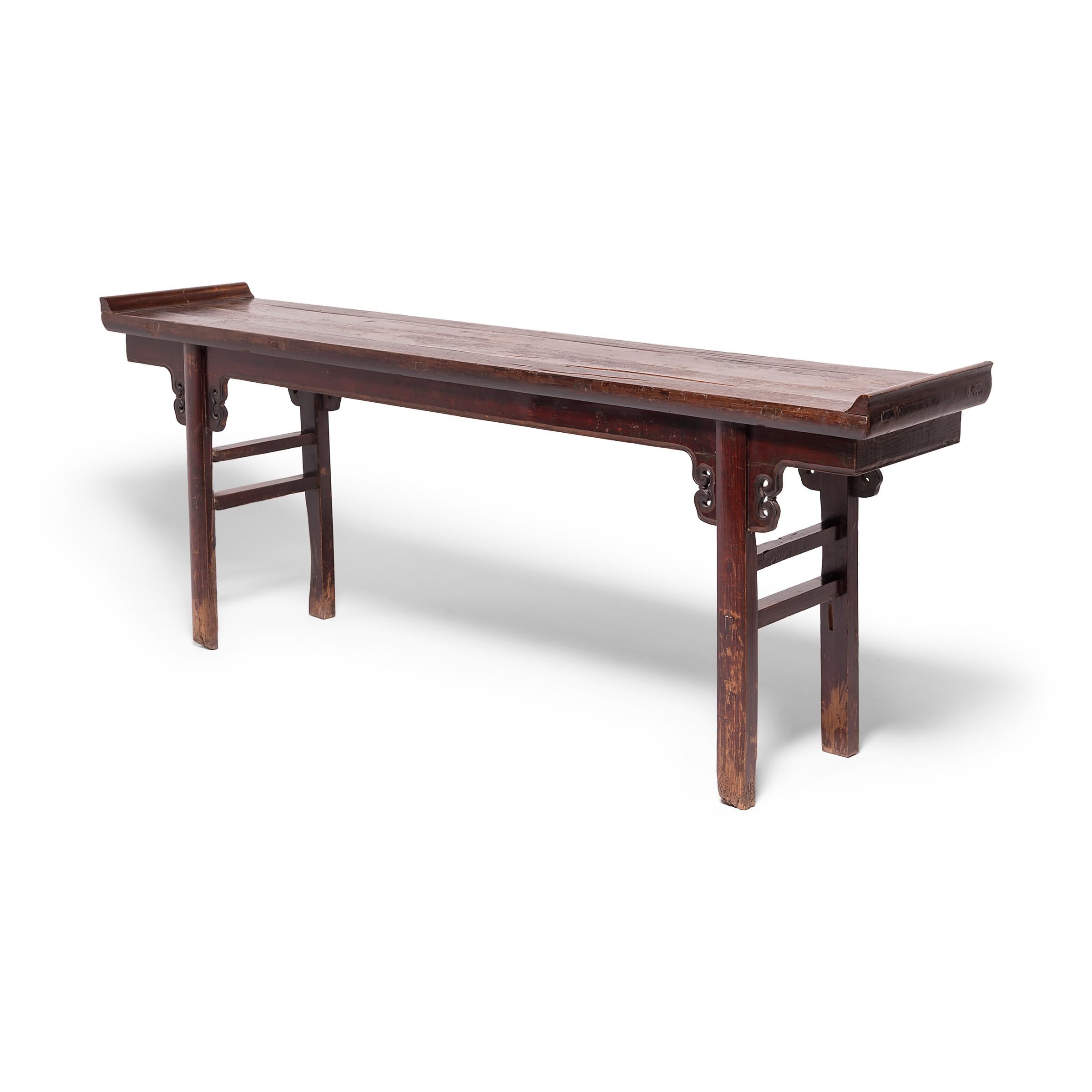 Although this beautiful 19th century altar table was crafted in the late Qing-dynasty, its refined form hearkens back to earlier Ming-dynasty designs. The altar's wide tabletop surface is adorned with everted flanges and supported by rounded legs,