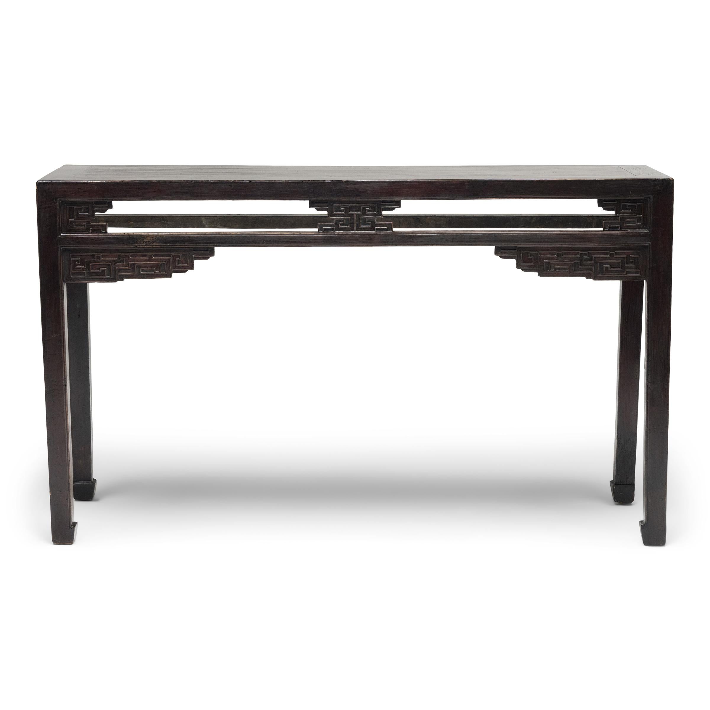 This early 20th-century console table has clean lines and minimalist appeal, simply decorated with relief-carved accents and an allover dark lacquer finish. Crafted with mortise-and-tenon joinery, without the use of nails or screws, the table