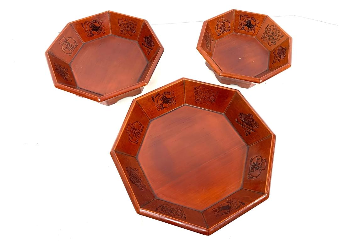 A decorative and well made nested group of five Octagonal Lacquered Wood Trays. In a fine and smooth medium honey tone lacquer with a hint of Cinnebar. The trays are in graduated size from small on top to large and each repeat four black incised