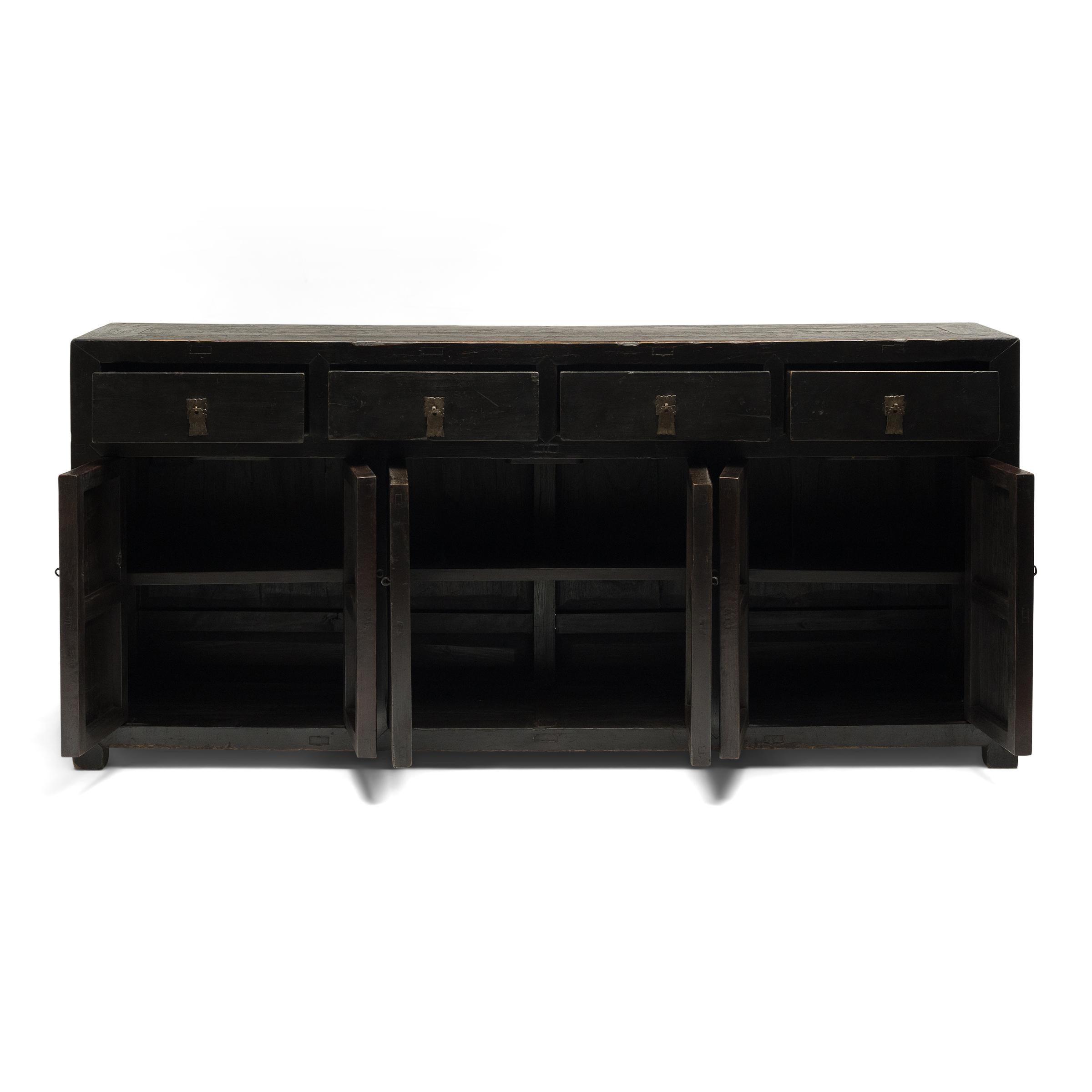 This provincial coffer from northern China has a simple, clean-lined form and a striking finish of dark lacquer. Dated to the mid-19th century, the cabinet is crafted of northern elm (yumu) using traditional mortise-and-tenon joinery, without the