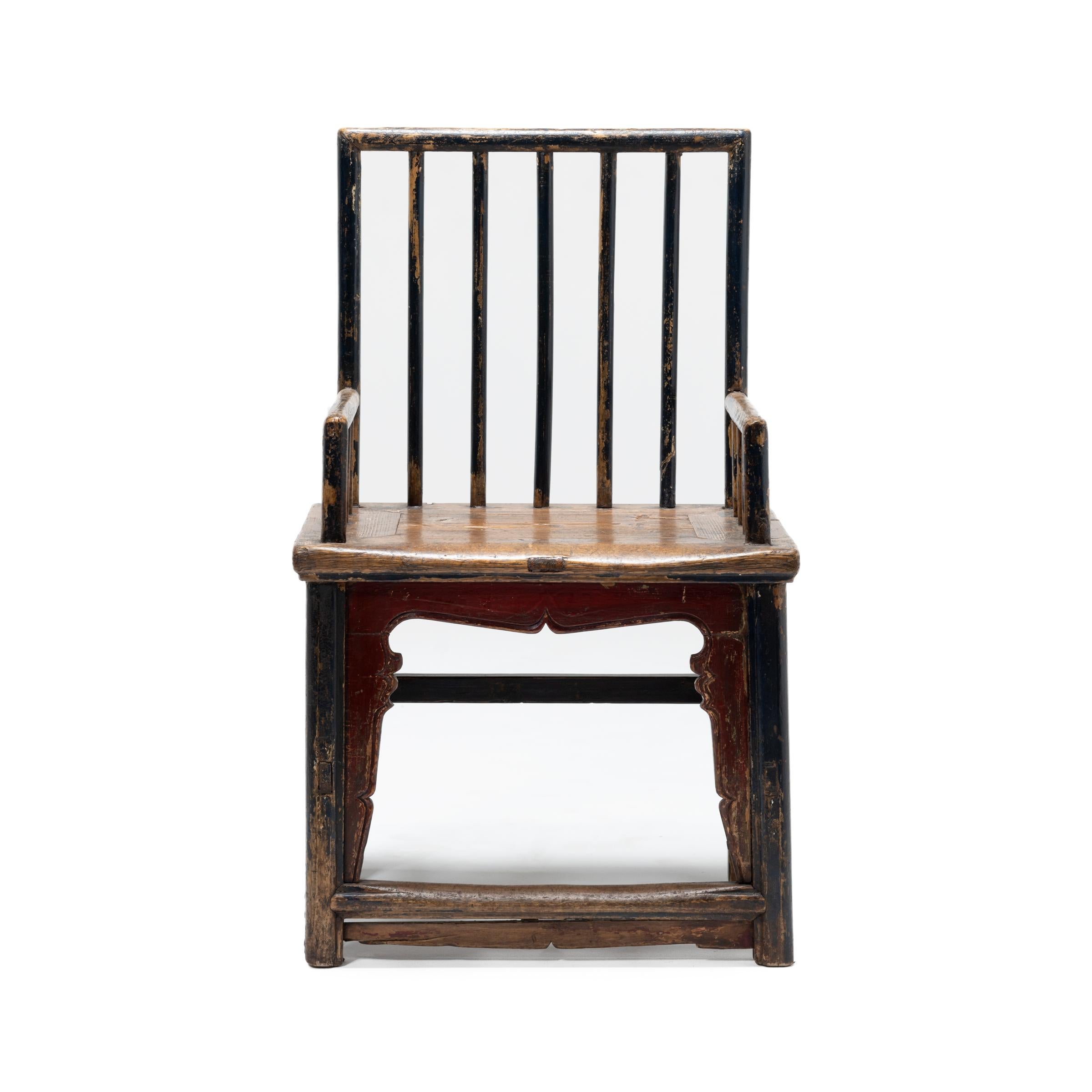 Dieser kuriose Stuhl mit Spindellehne aus dem 19. Jahrhundert widersetzt sich den traditionellen Formen der Qing-Dynastie. Der Stuhl ist eine Sammlung von Momenten aus früheren Epochen und enthält Elemente aus dem chinesischen Tischlerhandwerk, das