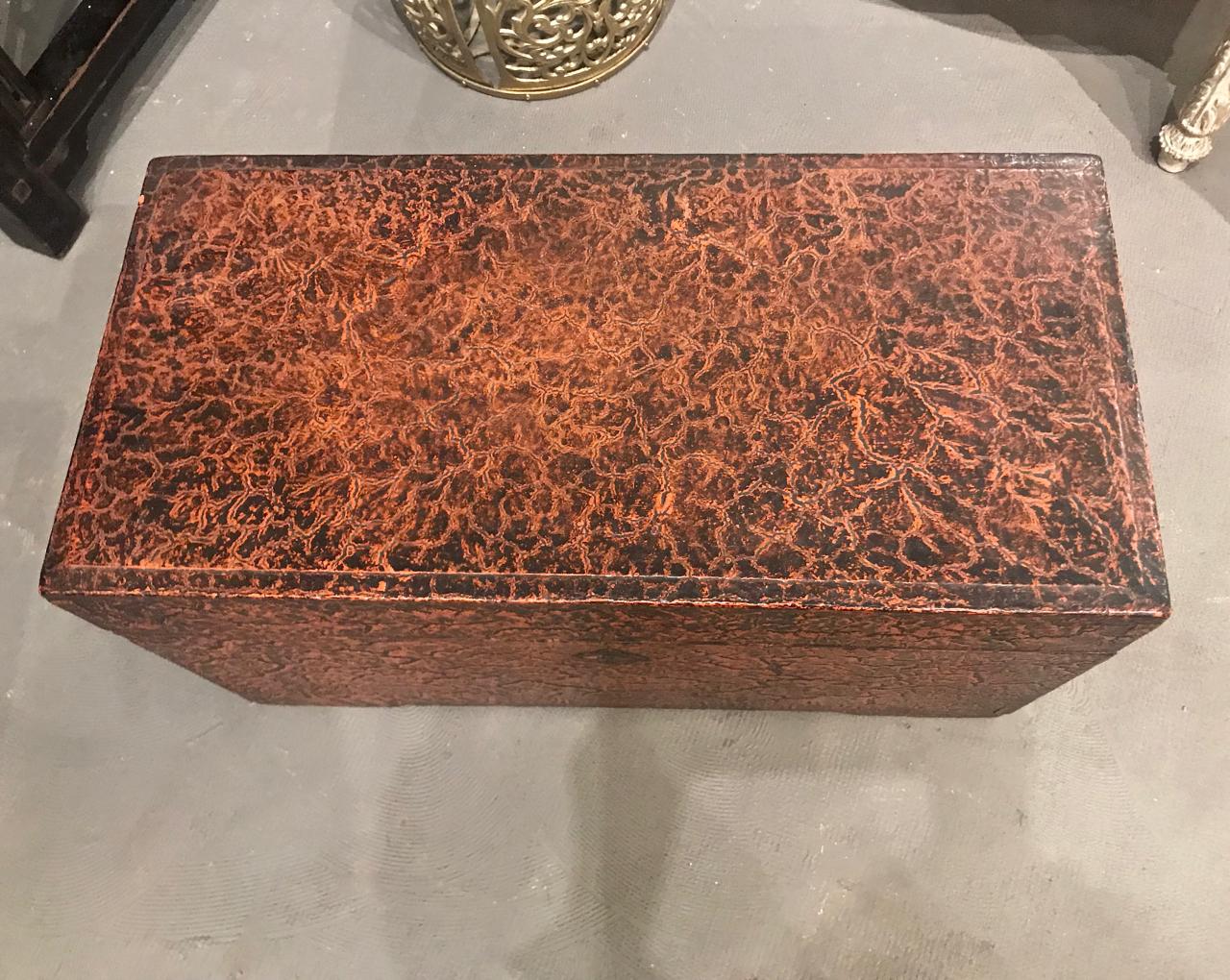 This is a charming and unusual Chinese faux alligator lacquered storage trunk. The trunk is in great original condition with all original elements present. The faux alligator lacquered surface adds interet and a bit of whimsy.