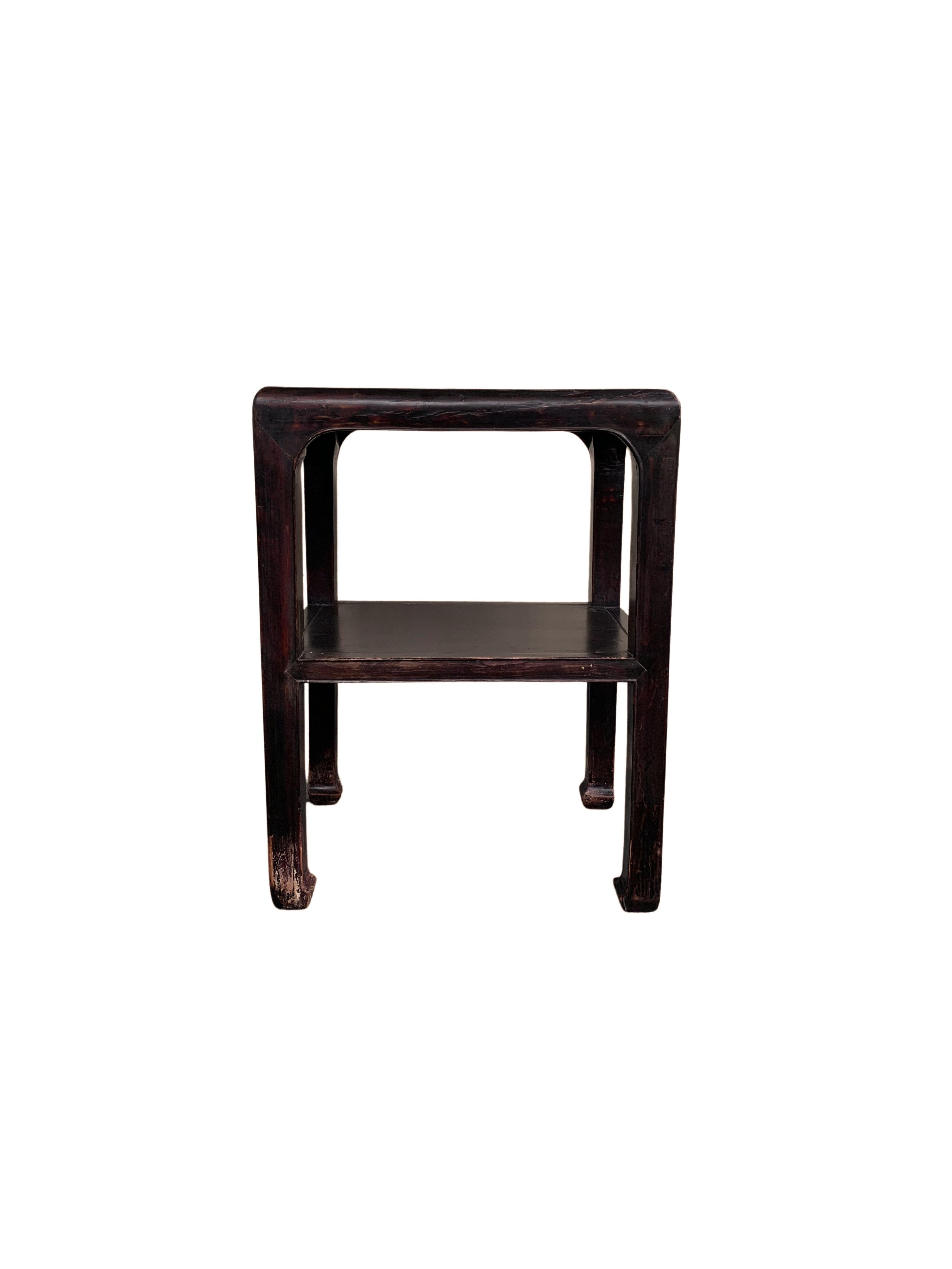 Cette élégante table laquée a été fabriquée en Chine du Nord au milieu du XXe siècle. Il présente des pieds élégants, joliment proportionnés et aux extrémités incurvées. Il comporte une étagère inférieure et un plateau carré. Le bois a
