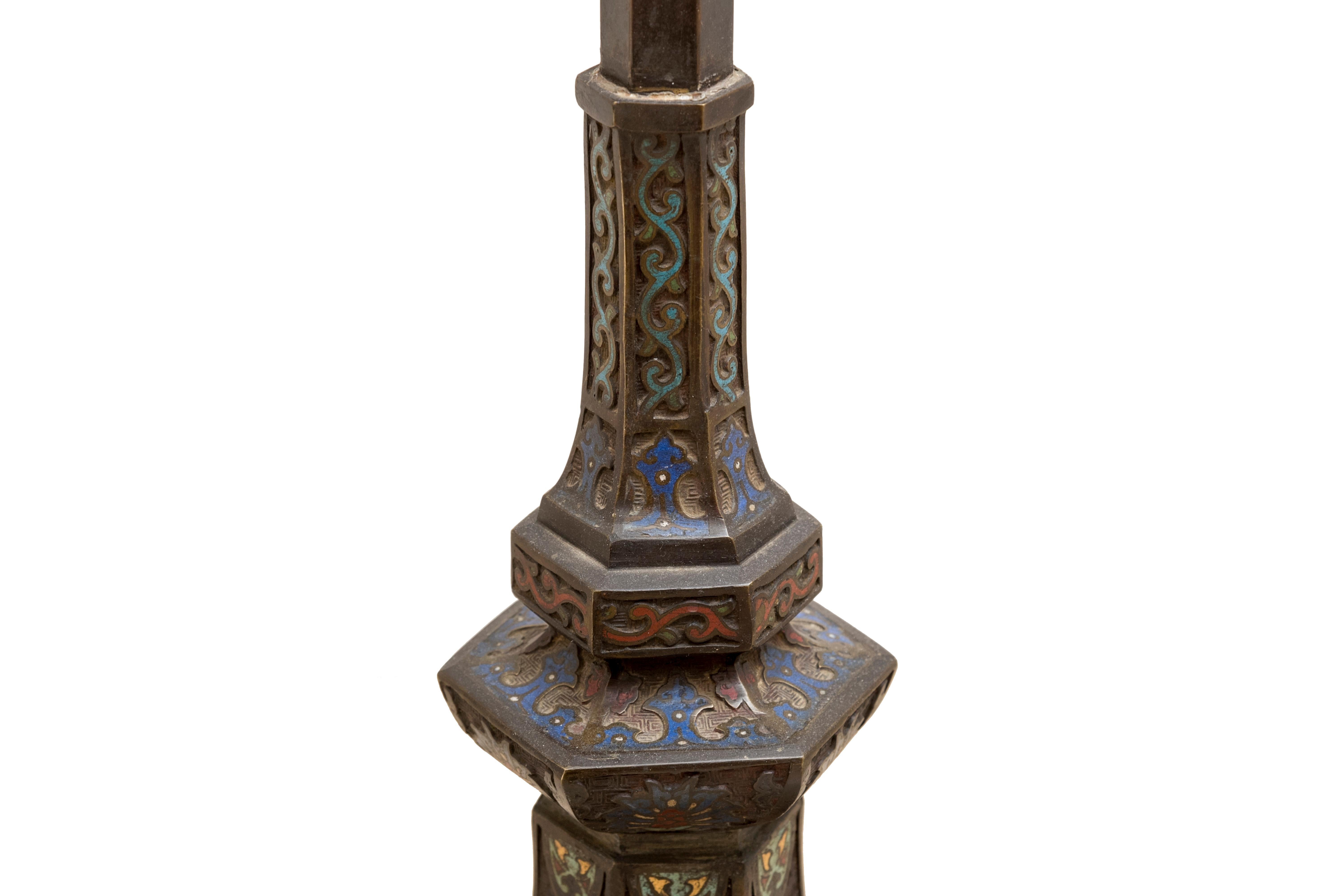 Tall hexagonal lantern in bronze with a blue, red and green enamel openwork with stylized lotus flower motives. The shaft has a nice brown patina. The base is decorated with taotie masks and a lotus flower on a background designed to imitate