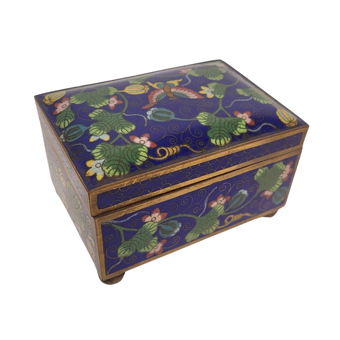 Gorgous  cloisonné enamel box, made in the 20th century in China. It has a simple structure, rectangular profile and a slightly domed lid; and is slightly raised from the ground by small legs in gilded brass as well as the profile of the entire box.