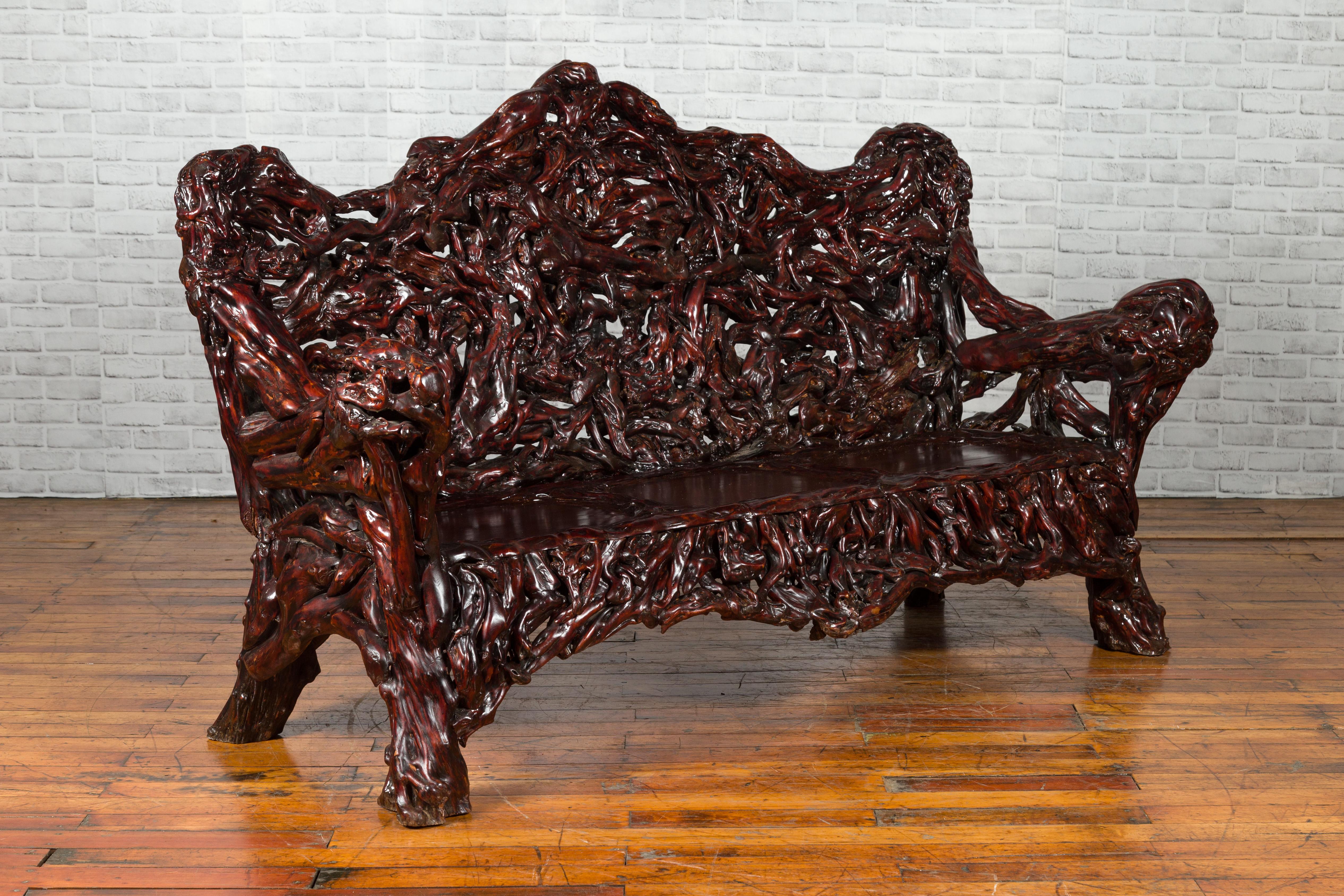 A Chinese settee from the late 20th century, hand carved out of one complete azalea root. Created in China during the later years of the 20th century, this striking settee was hand carved from an azalea root and lacquered to its reddish brown hue.