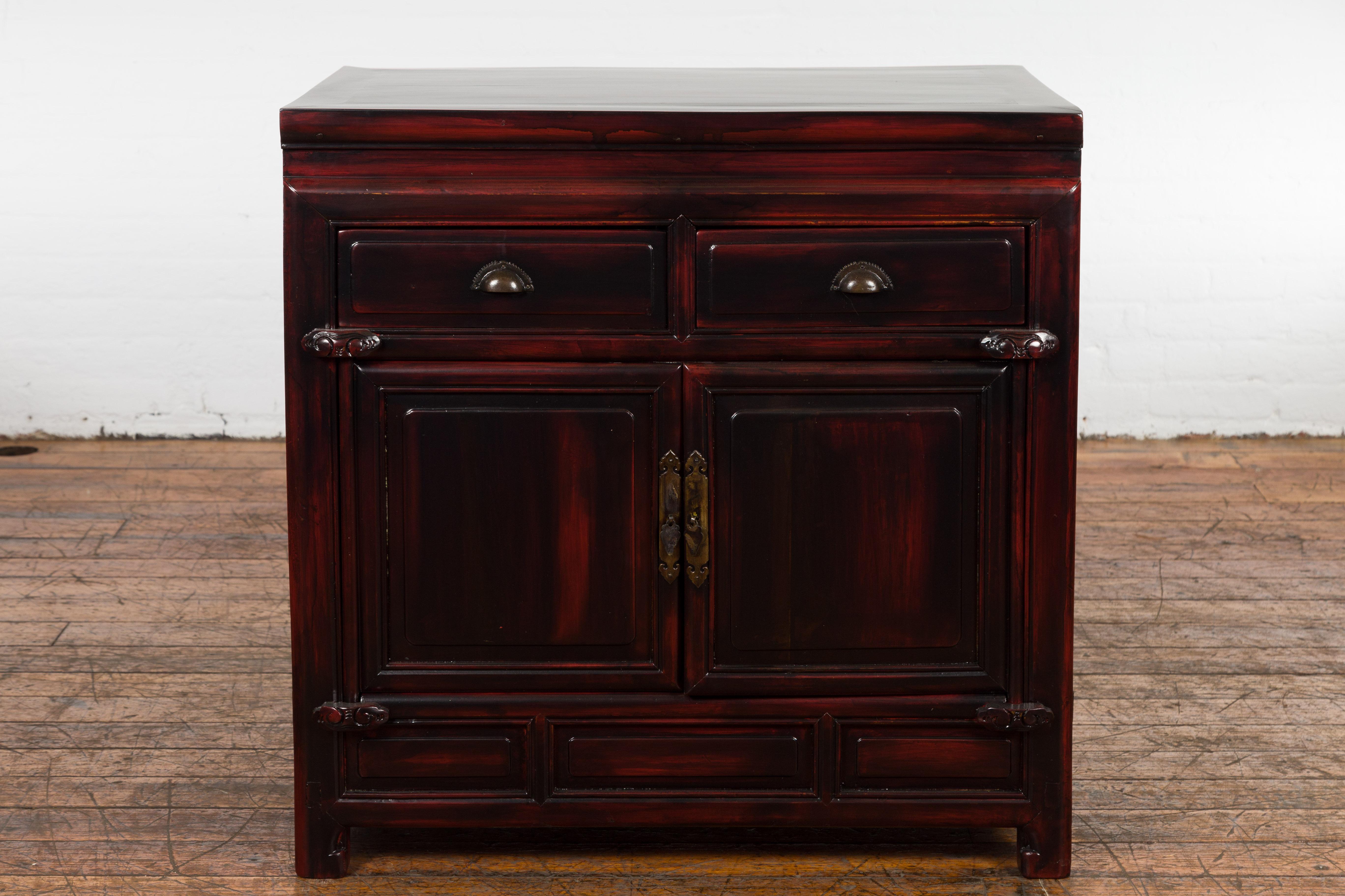 A Chinese late Qing Dynasty period side cabinet from the early 20th century with two drawers, two doors and custom reddish black lacquer. Created in China during the late Qing Dynasty period in the early years of the 20th century, this side cabinet