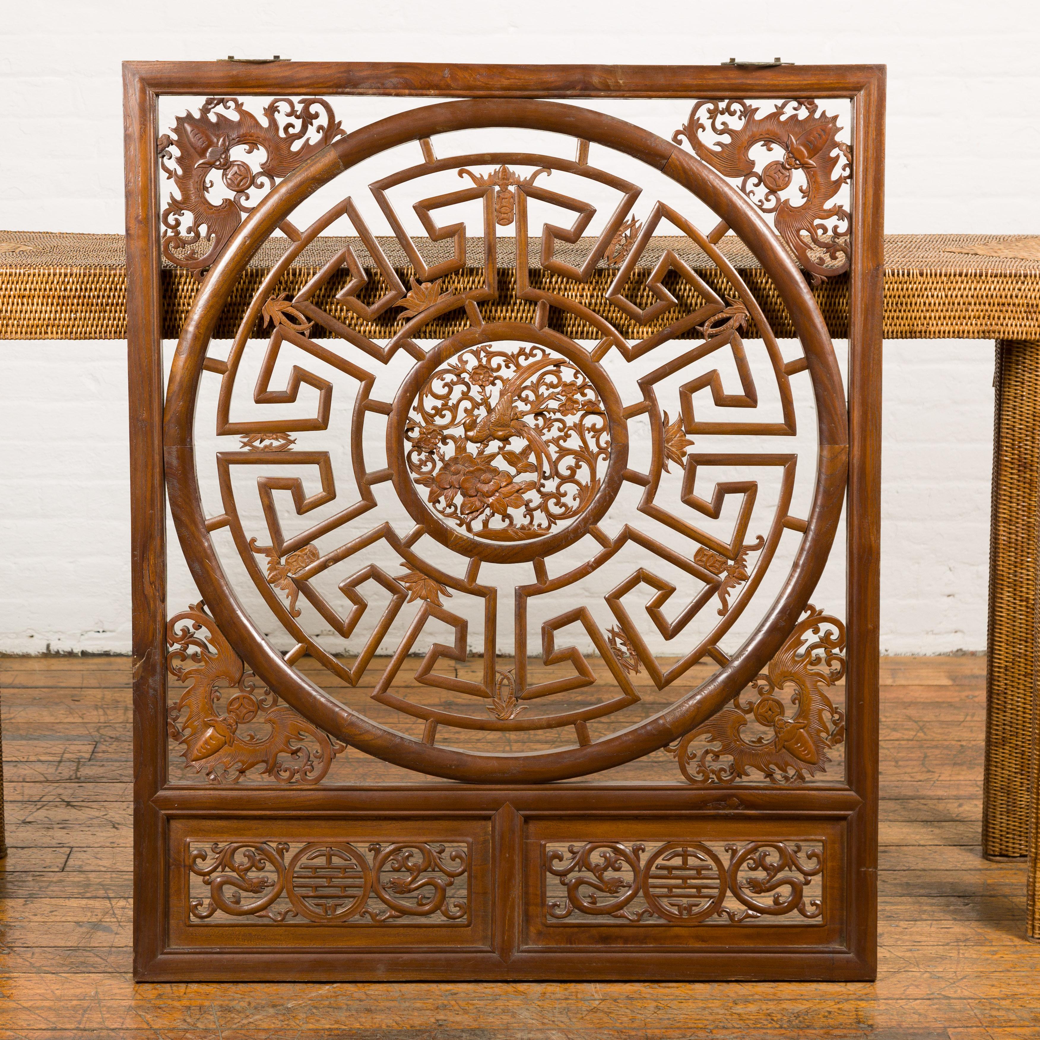 Pannello in legno di olmo cinese del periodo della tarda dinastia Qing, circa 1900, con fenice intagliata nel medaglione centrale, circondata da fiori, pipistrelli e fogliame a scorrimento. Prova il fascino dell'arte cinese con questo pannello in