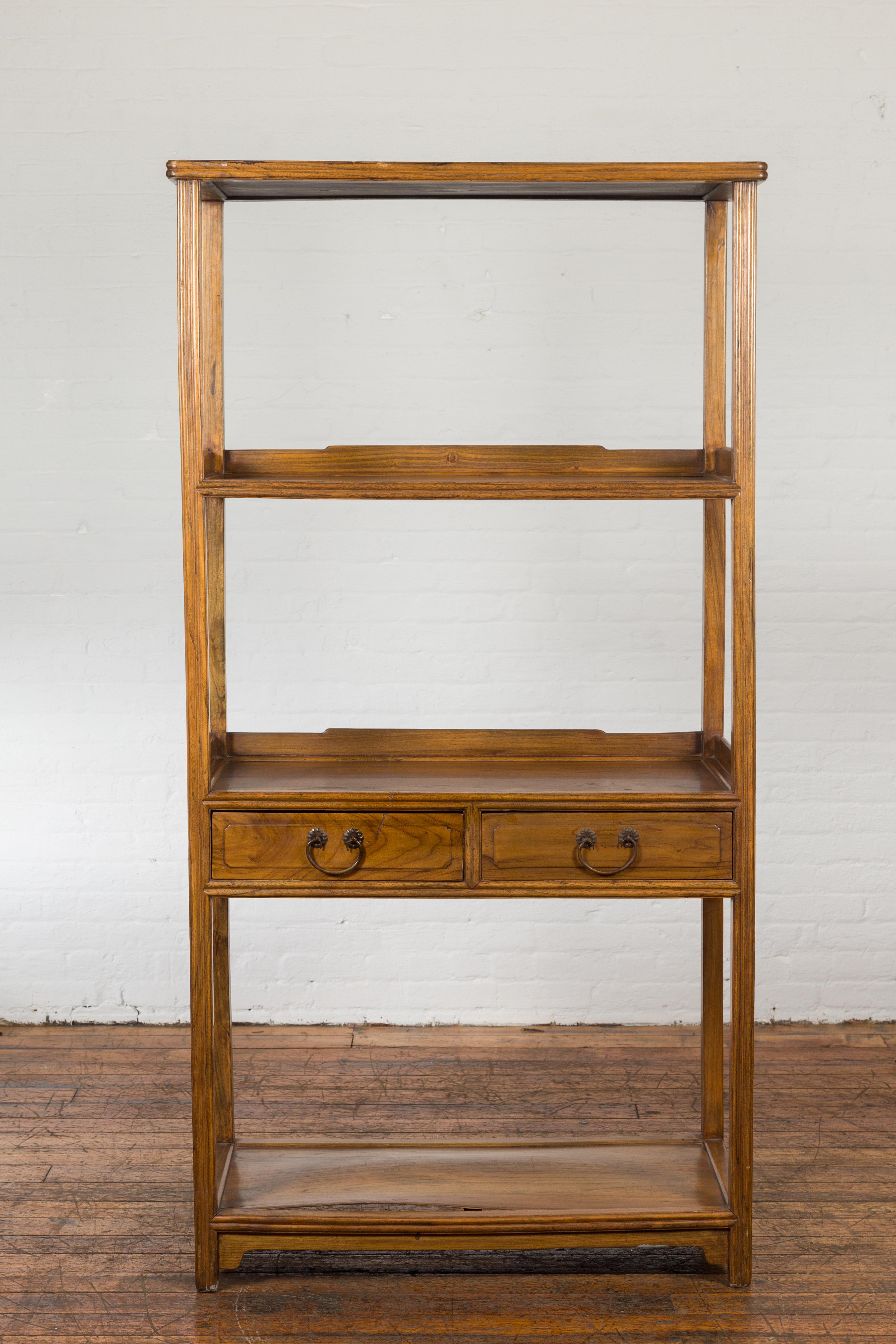 A Chinese late Qing Dynasty period bookcase from the early 20th century with classic design, four shelves and two drawers. Created in China during the late Qing Dynasty period in the early years of the 20th century, this wooden bookcase features a