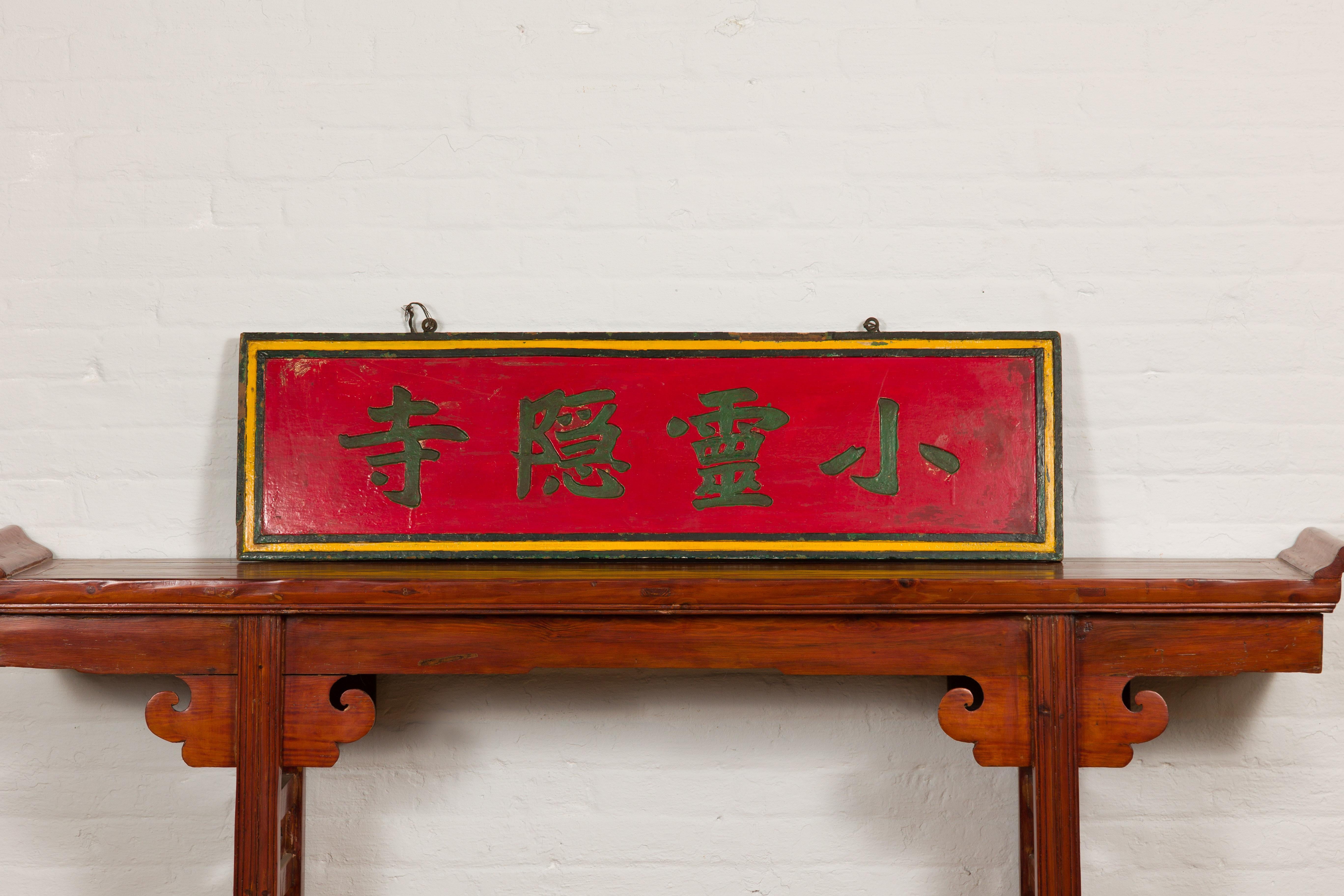 A Chinese late Qing Dynasty period red lacquered shop sign with hand carved calligraphy and black and yellow frame. Showcasing a rich history, this late Qing Dynasty period Chinese shop sign is an elegant piece that transports you to a bygone era.
