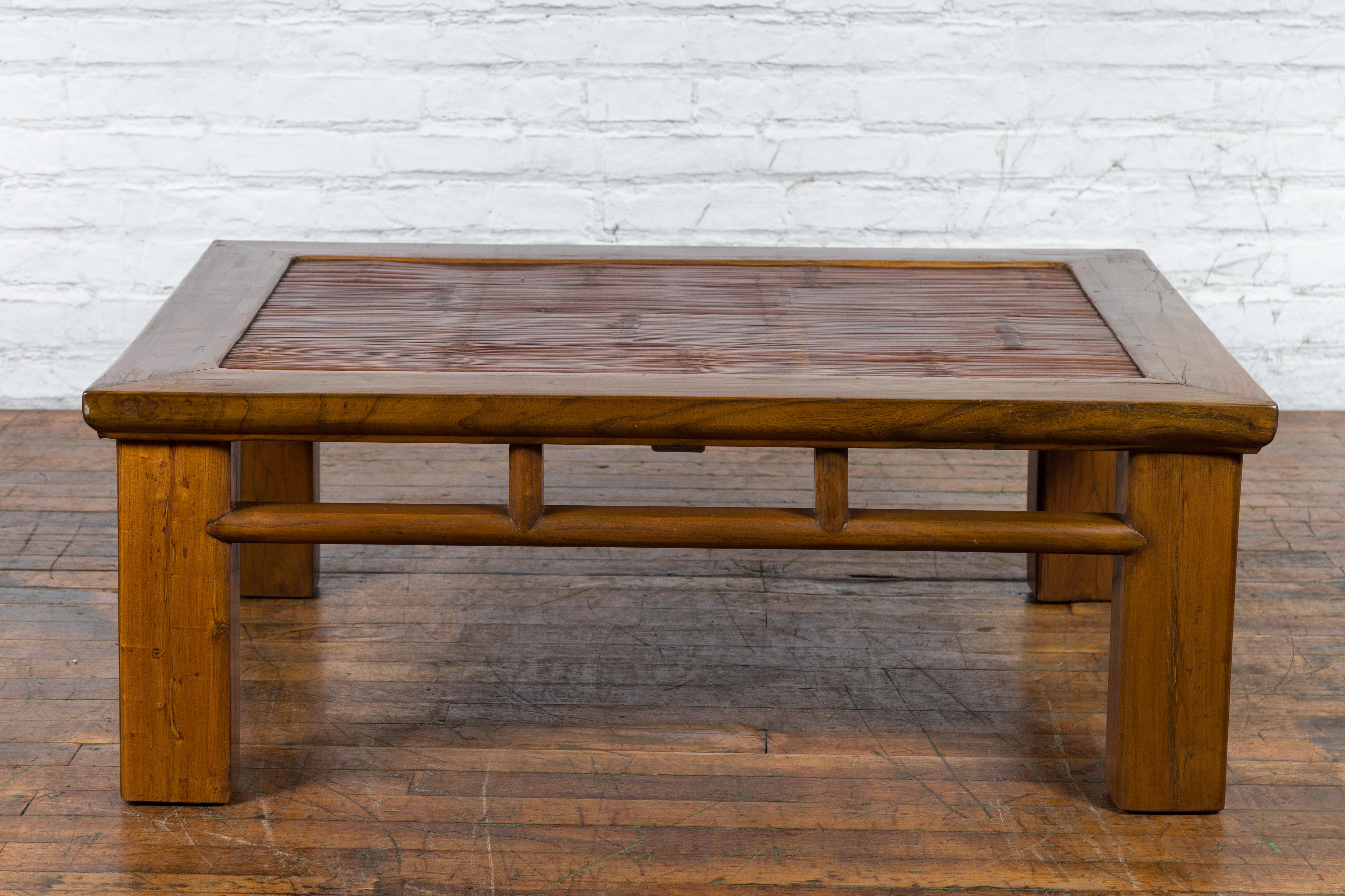 A Chinese Late Qing Dynasty period wooden low table from the early 20th century with bamboo top and straight legs, perfect to be used as a coffee table. Created in China during the Late Qing Dynasty in the early years of the 20th century, this low