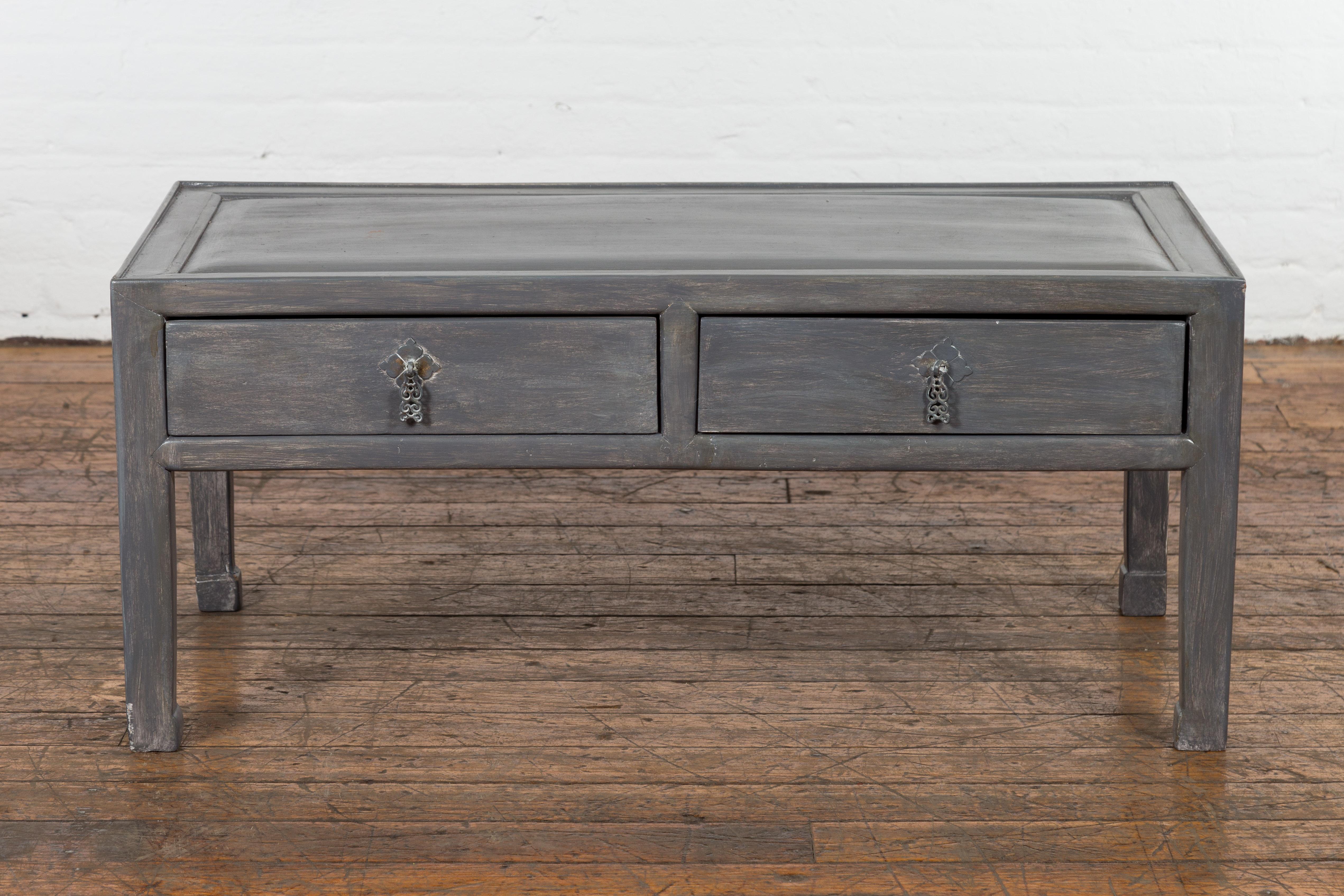 A Chinese late Qing Dynasty low table from the early 20th century, with two drawers, horse hoof legs, slightly recessed top, newly and professionally refreshed with a silver grey lacquer with white underlay, perfect to be used as a coffee table.