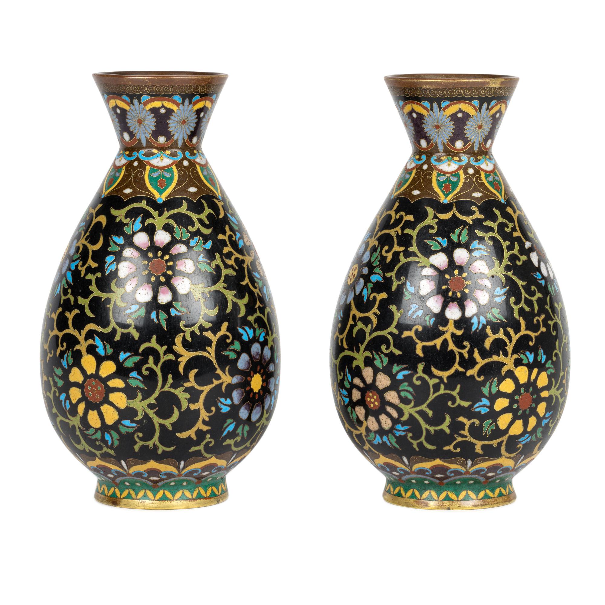 Un'eccezionale e splendida coppia di antichi vasi cinesi Qing in smalto cloisonné decorati con motivi floreali risalenti alla fine del XIX o all'inizio del XX secolo. I vasi a forma di bottiglia bulbosa si ergono su uno stretto piede a forma di cono