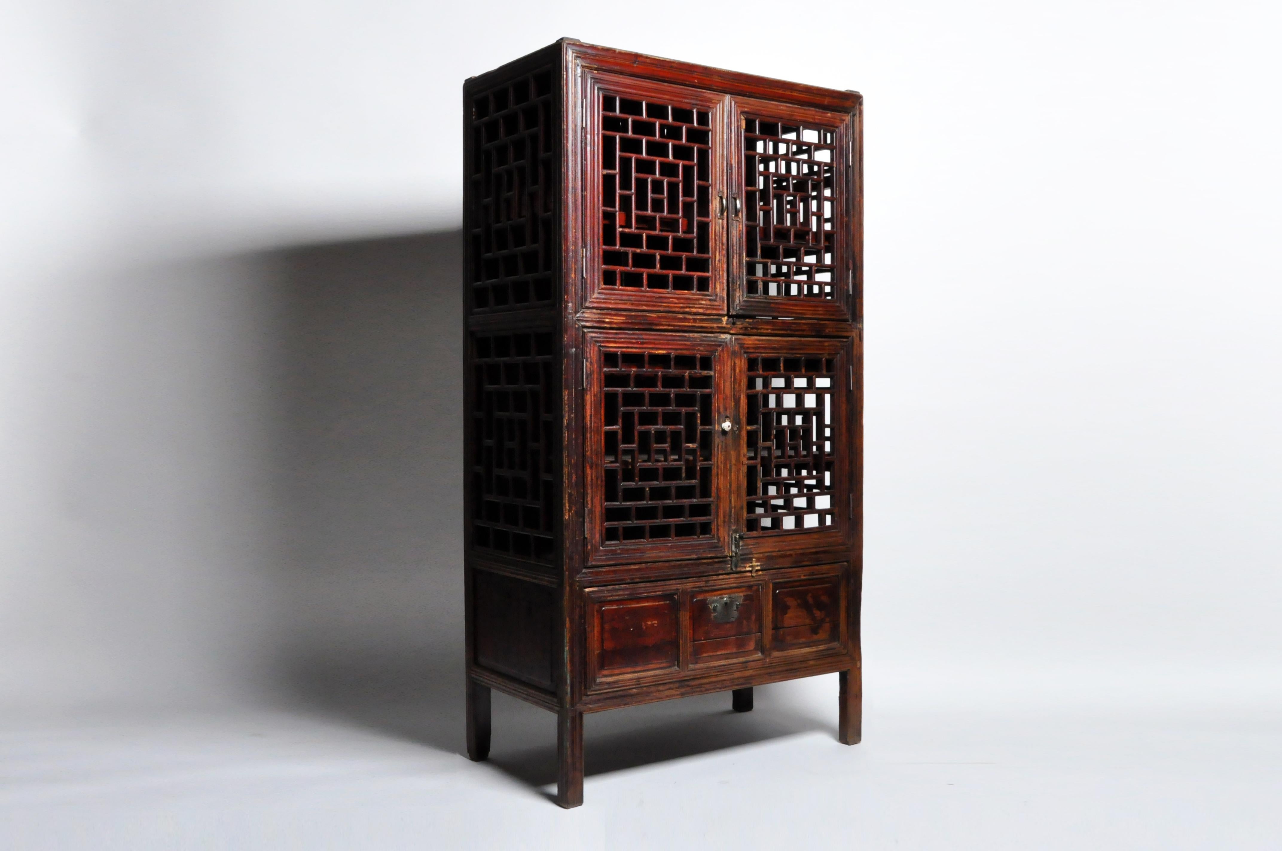 Chinese furniture is known for its practicality, beauty, and sturdy construction. This storage cabinet features lattice doors and an oxblood lacquer finish that has aged to a beautiful patina. Though this is a “softwood” piece; made from Fir, it has