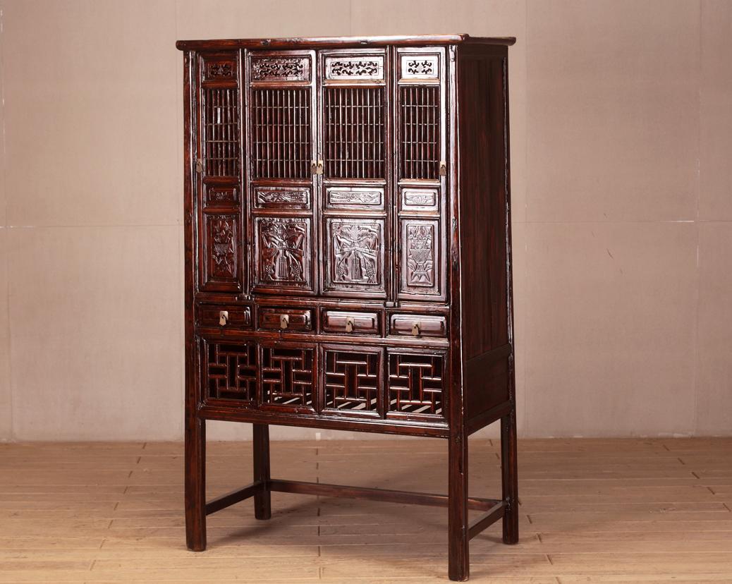 Chinesische Möbel sind für ihre Zweckmäßigkeit, Schönheit und robuste Konstruktion bekannt. Dieser Schrank hat Gittertüren und eine Lackierung, die eine schöne Patina angenommen hat. Obwohl es sich um ein 