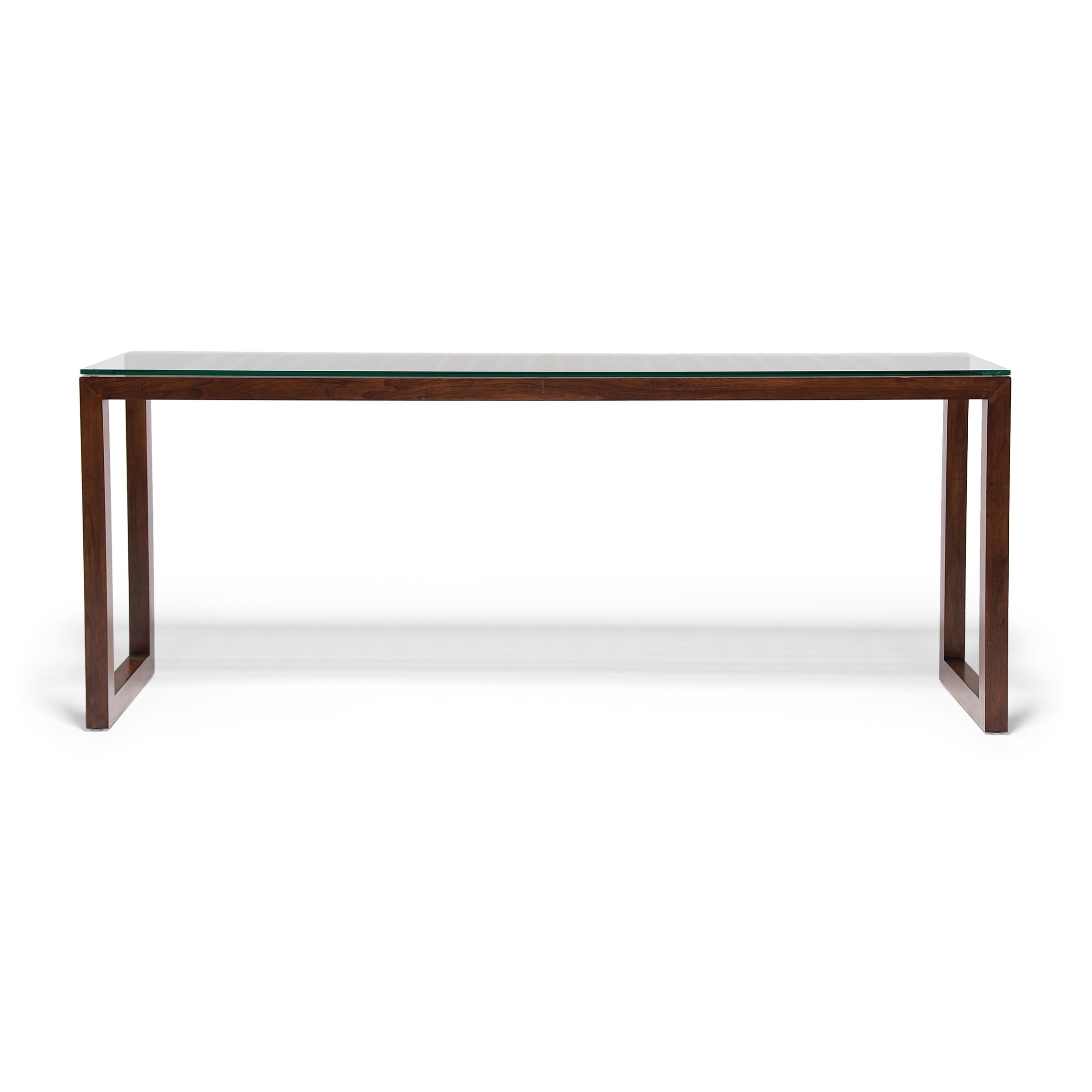 The clean lines of this contemporary console table remind us of the minimalist restraint of Ming-dynasty furniture design. The waterfall table has a balanced form, with square corners, open sides, and straight legs linked by a simple stretcher. The
