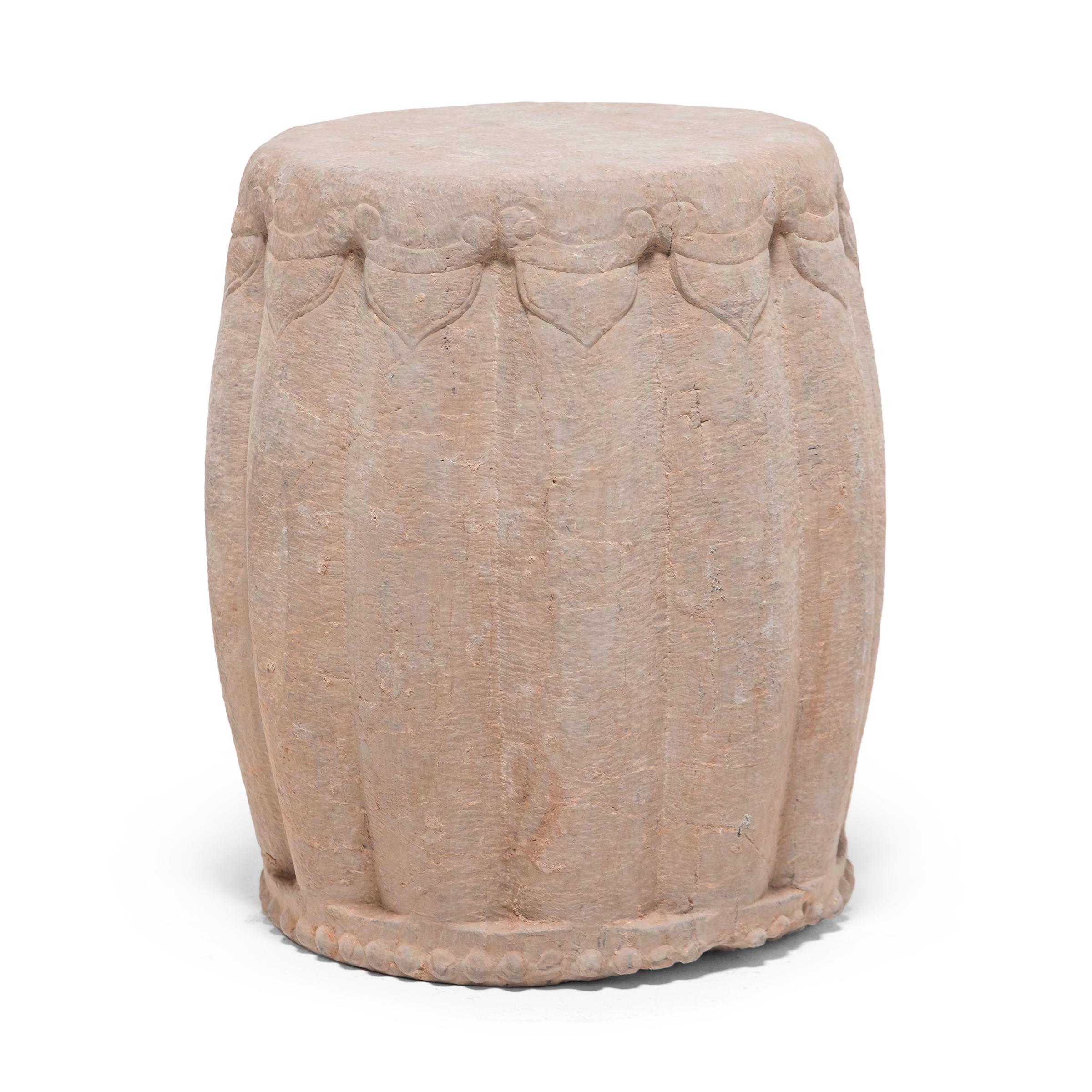 Carved from a solid block of limestone, this drum-form garden stool began its life in China's Shanxi province in the early 20th century. Ribbed and rounded, the stool suggests a melon, an ancient Chinese symbol of perpetuity. The seat is framed by a