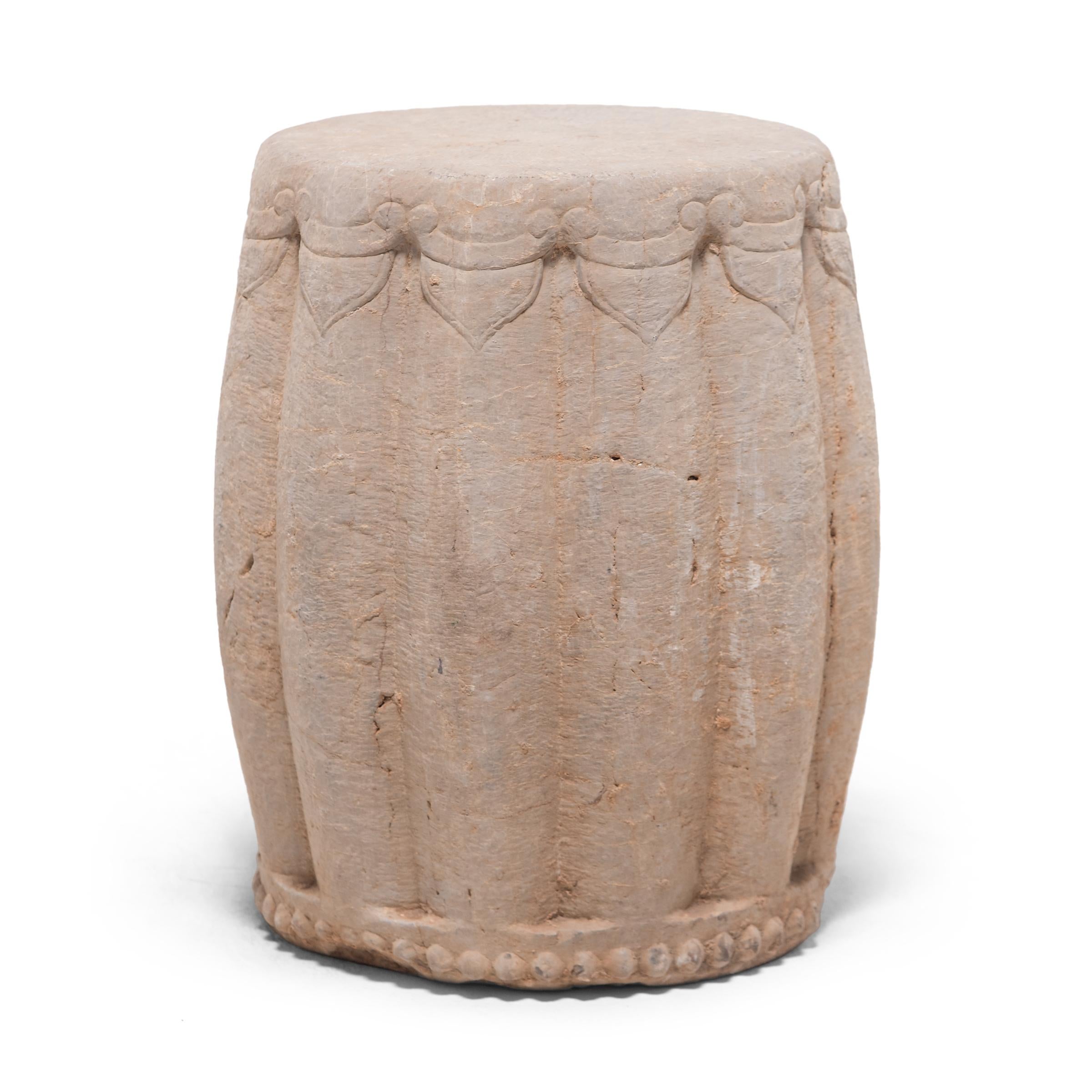 Carved from a solid block of limestone, this drum-form garden stool began its life in China's Shanxi province in the early 20th century. Ribbed and rounded, the stool suggests a melon, an ancient Chinese symbol of perpetuity. The seat is framed by a