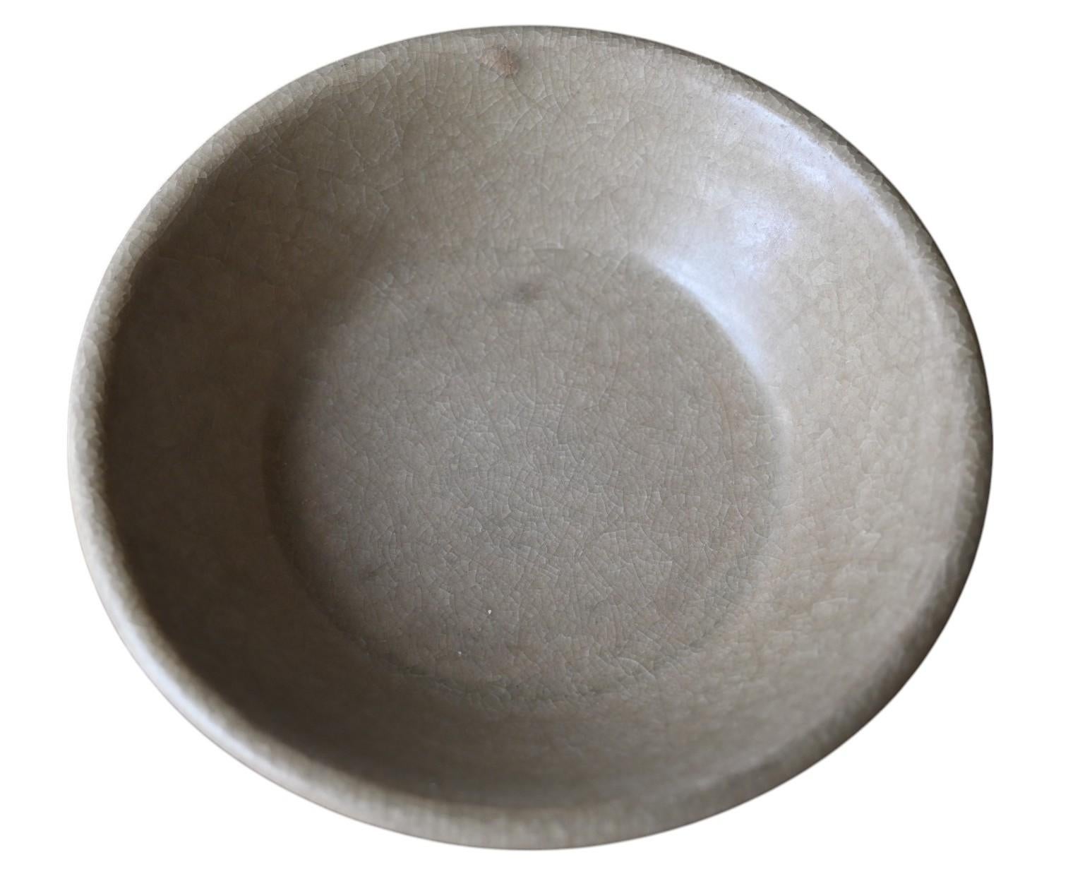 Chinese Longquan celadon brush washer, Southern Song Dynasty (1127-1279), covered with a sea green glaze, the sides slightly everted at the rim, rising on a tapered foot.
Presented on a 19th century wooden base.
Brush bowl diameter 14 cm, height 4.2