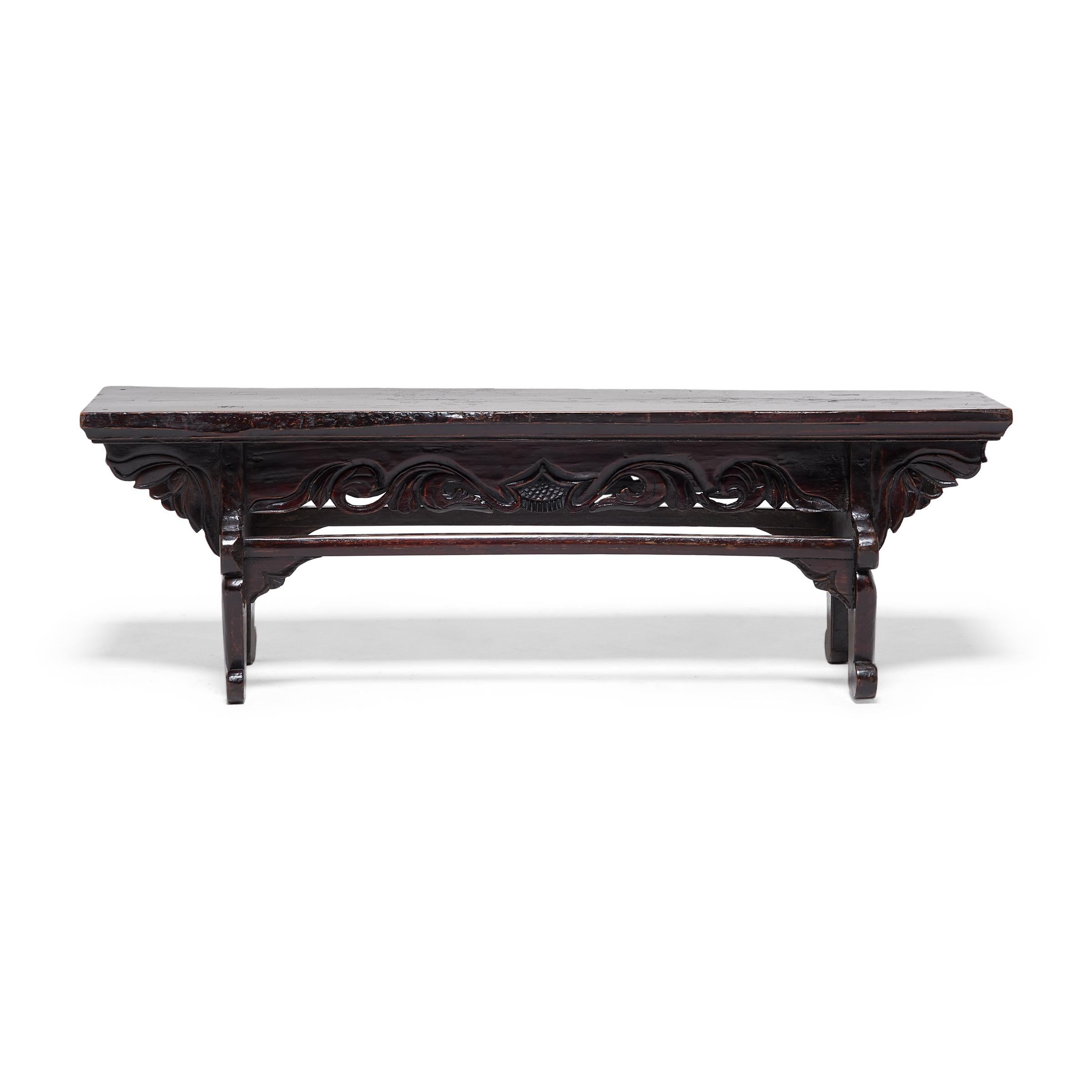 Esta mesa baja del siglo XIX es en realidad un peldaño utilizado para entrar y salir fácilmente de una cama de día elevada. Fabricado en madera de olmo del norte (yumu), el escalón presenta una superficie superior de tablones, enjutas de loto