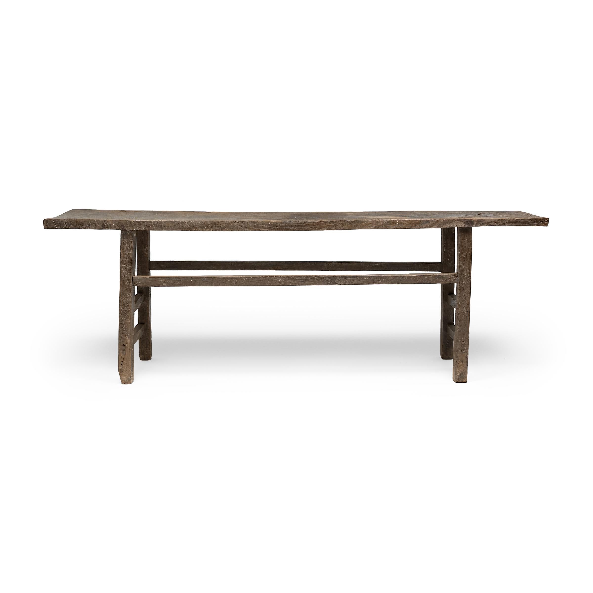 This low-profile rustic table was originally used in a provincial, Qing-dynasty home as a versatile surface for cooking, dining or drinking. Made of northern Chinese elmwood (yumu), the table has a plank-top surface and straight splayed legs