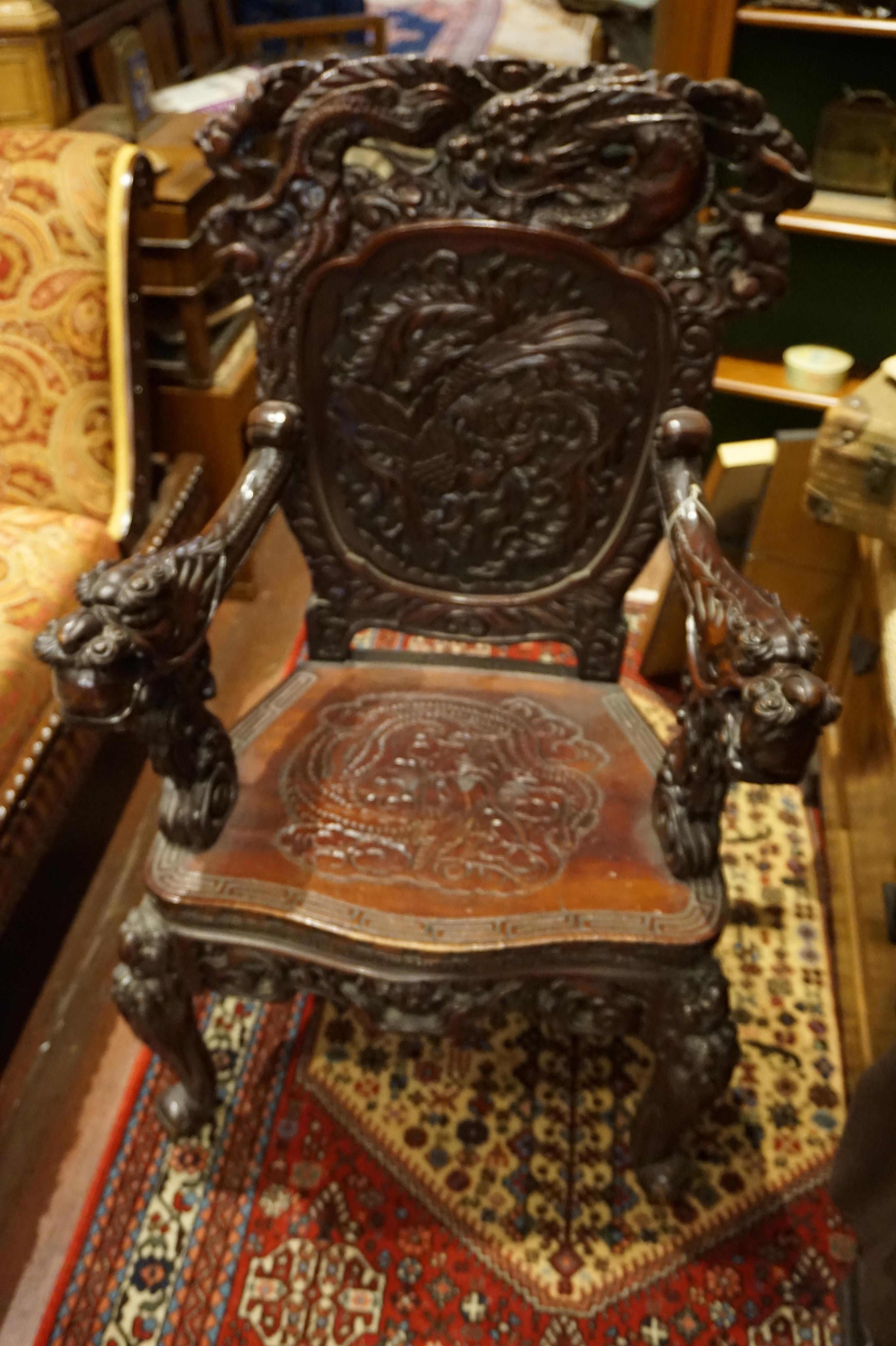 Chinese dragon and phoenix Minster's chair from 1890s. Hand carved majestic mahogany Dragon chair with intricate arms and detailed back depicting the phoenix with a dragon crest. Carved apron, forelegs and seat.