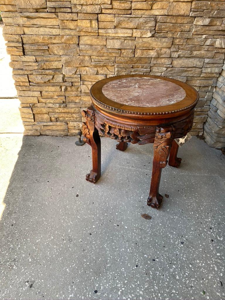 Chinese short side table hand carved mahogany with marble inset. Dragon faces carved to the top of each leg. We have another same size a little different wood color.