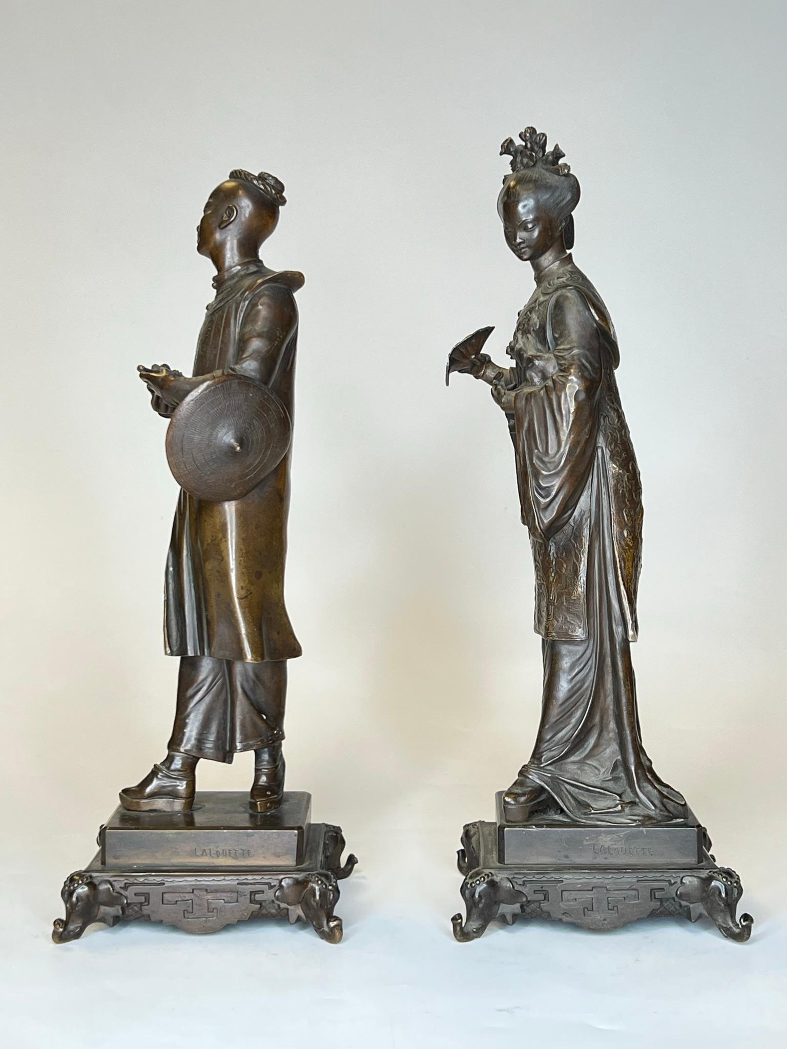 Chinese male and female figures in patinated bronze after the French artist,  Auguste Louis Lalouette (1826-1883).  Heights:  12.25 and 13 inches.