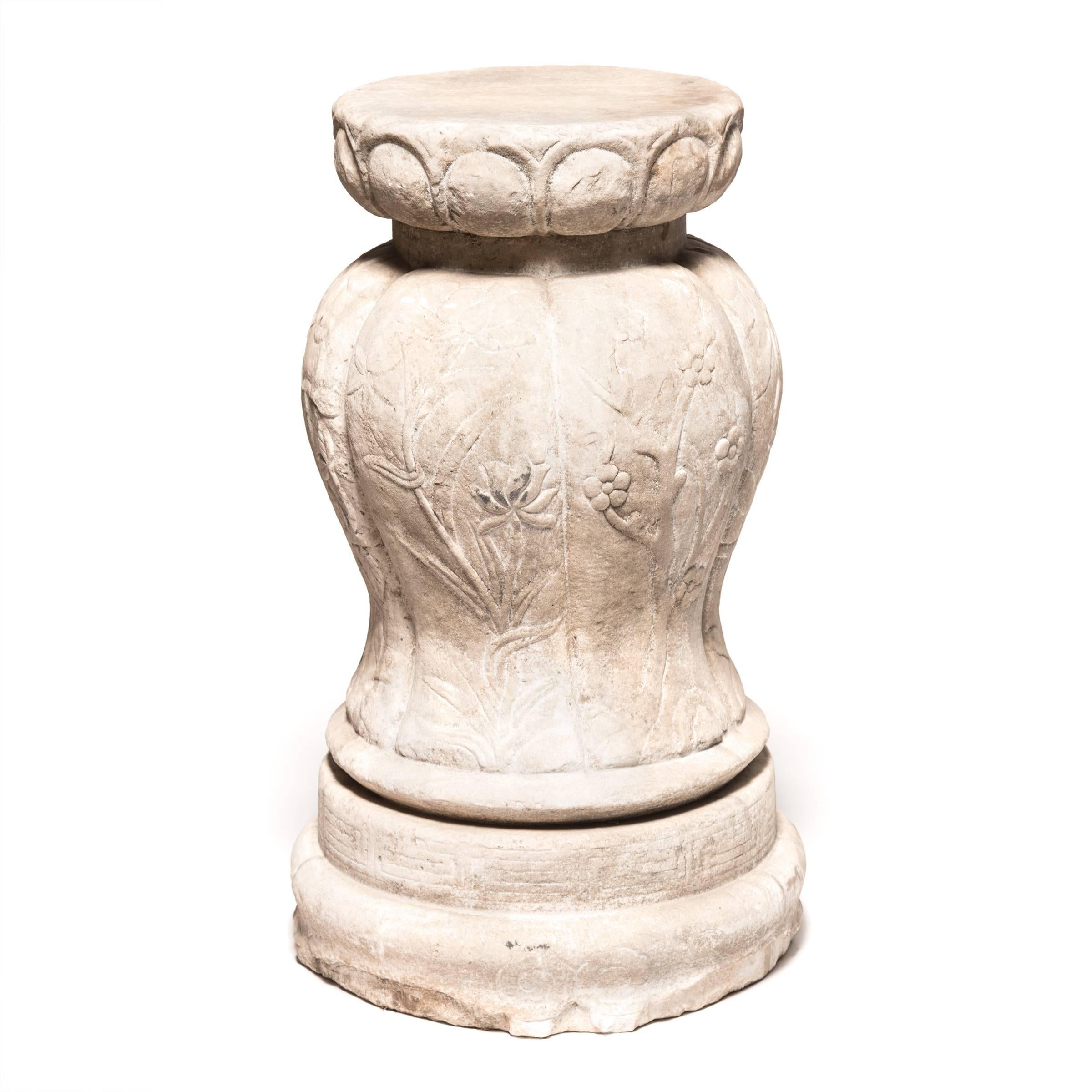 This finely carved marble pedestal is ideal for display inside or out. The raised pleats stand in for a melon’s ribs and flow down from the pedestal top to the stepped disc base. The dynamic relationship from rounded top to swelling center to