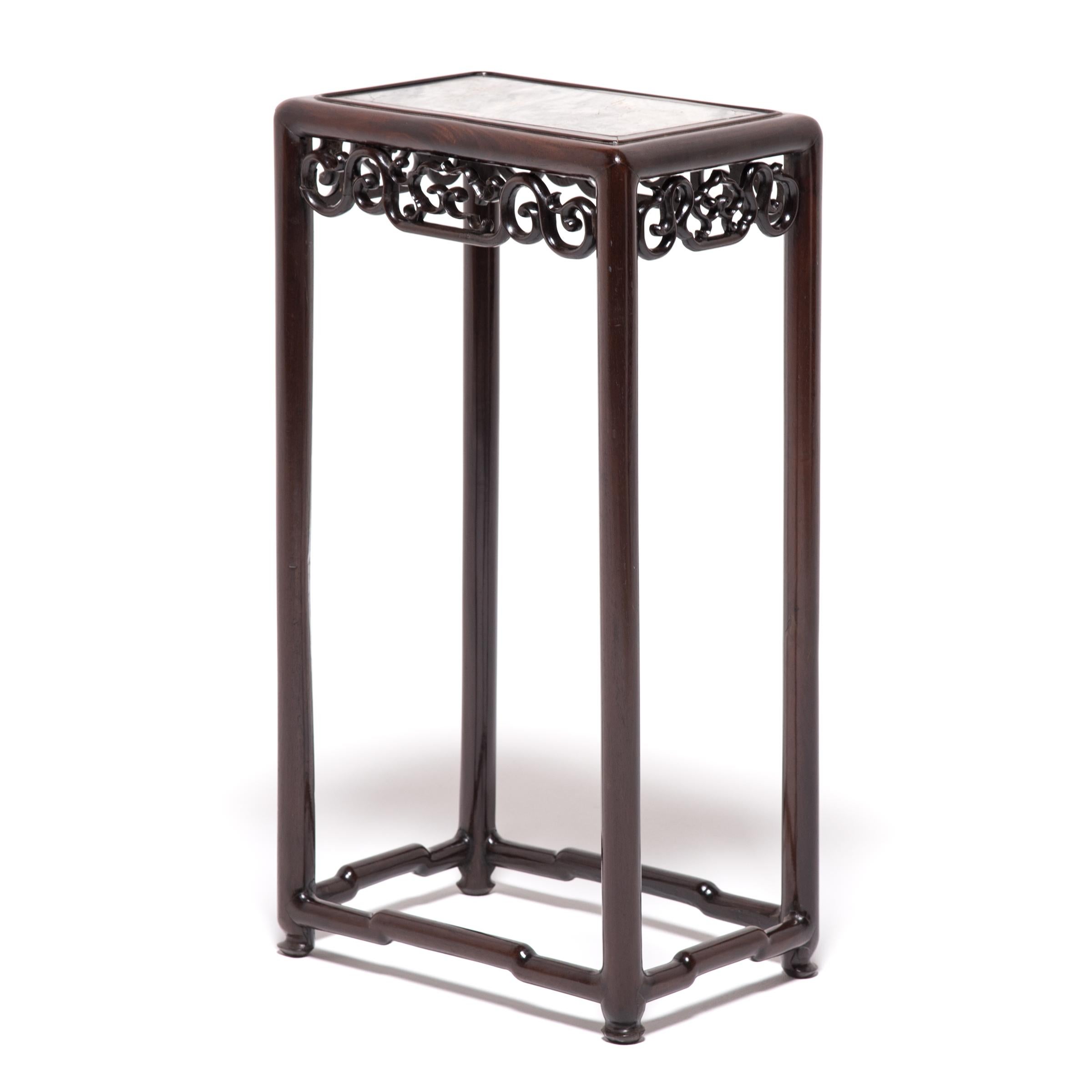 This elegant blackwood stand topped with marble was made in the bustling city of Shanghai during the Art Deco period. A product of the era, the table has an eclectic style of design that combines traditional craft motifs with bold, rich colors and