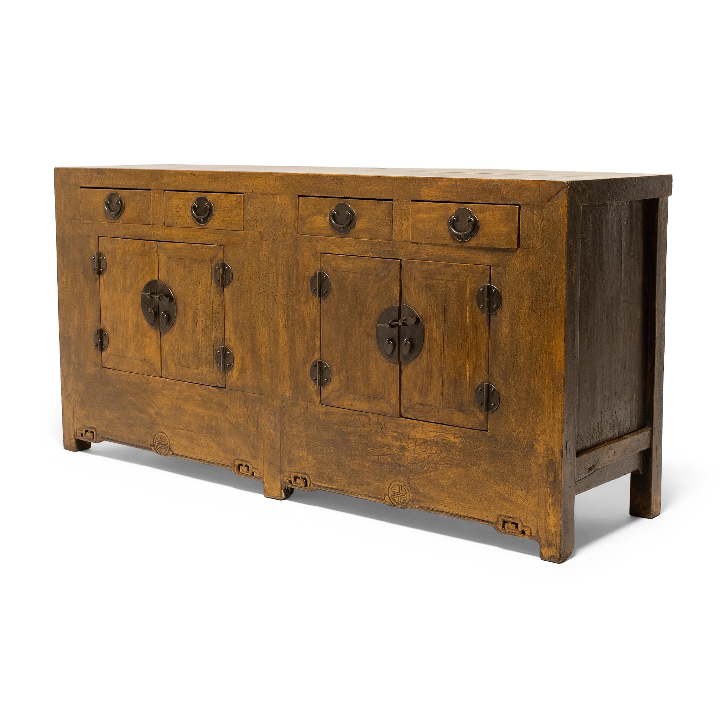While most Chinese lacquered furniture is black or red in color, this 19th-century storage coffer is colored by a marigold-yellow lacquer finish with a wonderful crackled texture. The coffer's clean-lined design is accented by striking full moon
